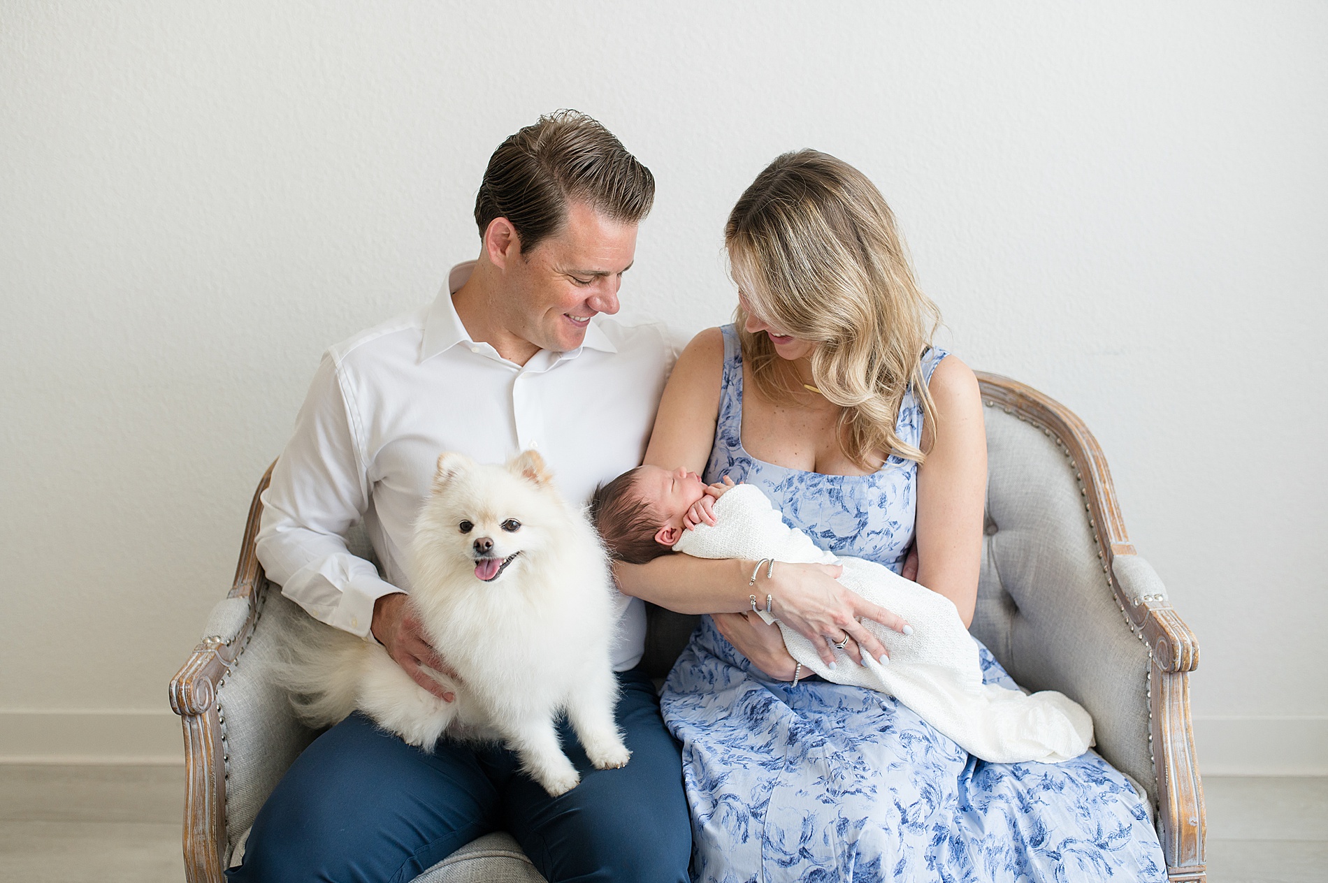 new parents hold newborn during studio session in Frisco TX