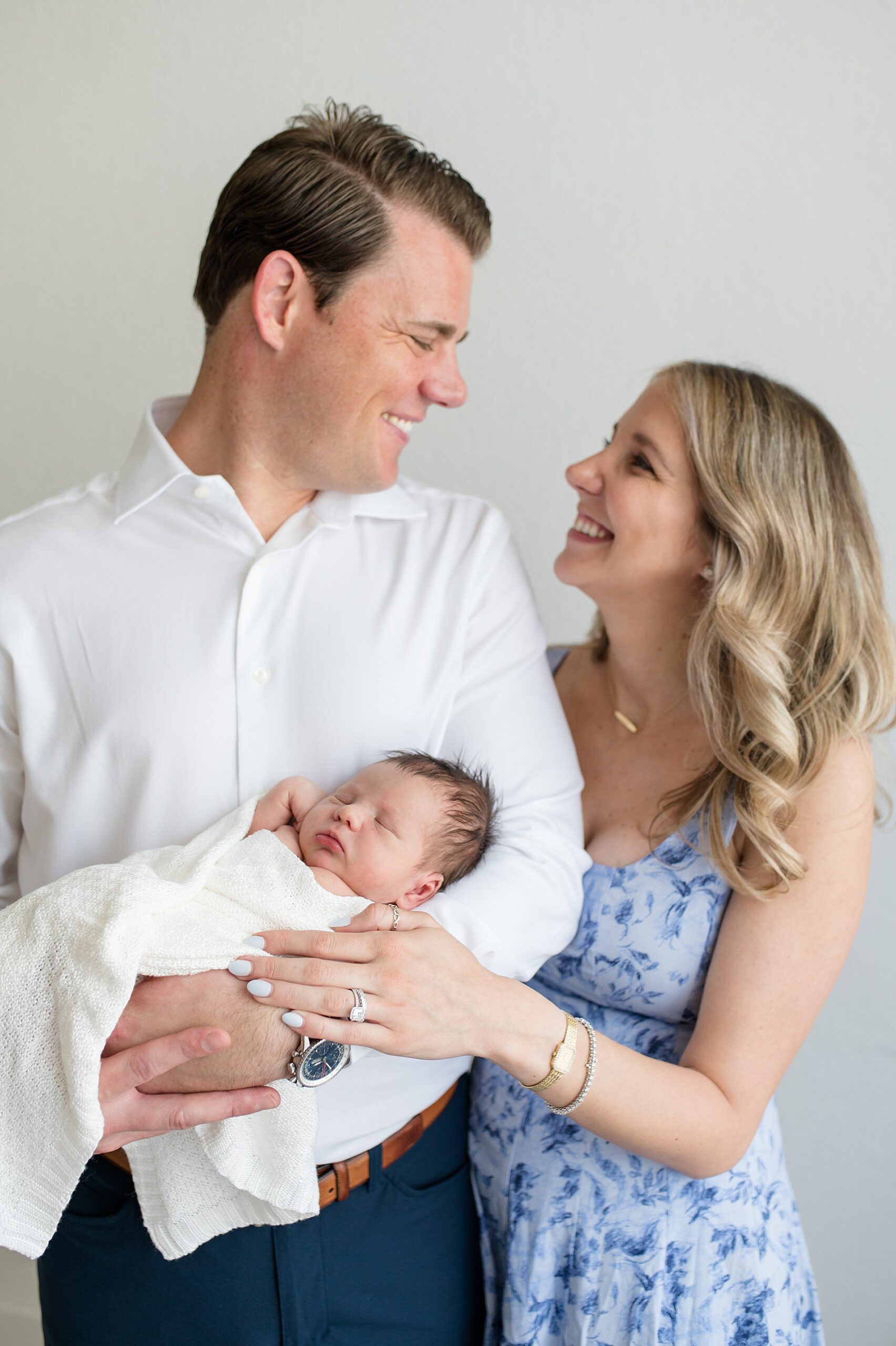 new parents look at each other while holding newborn