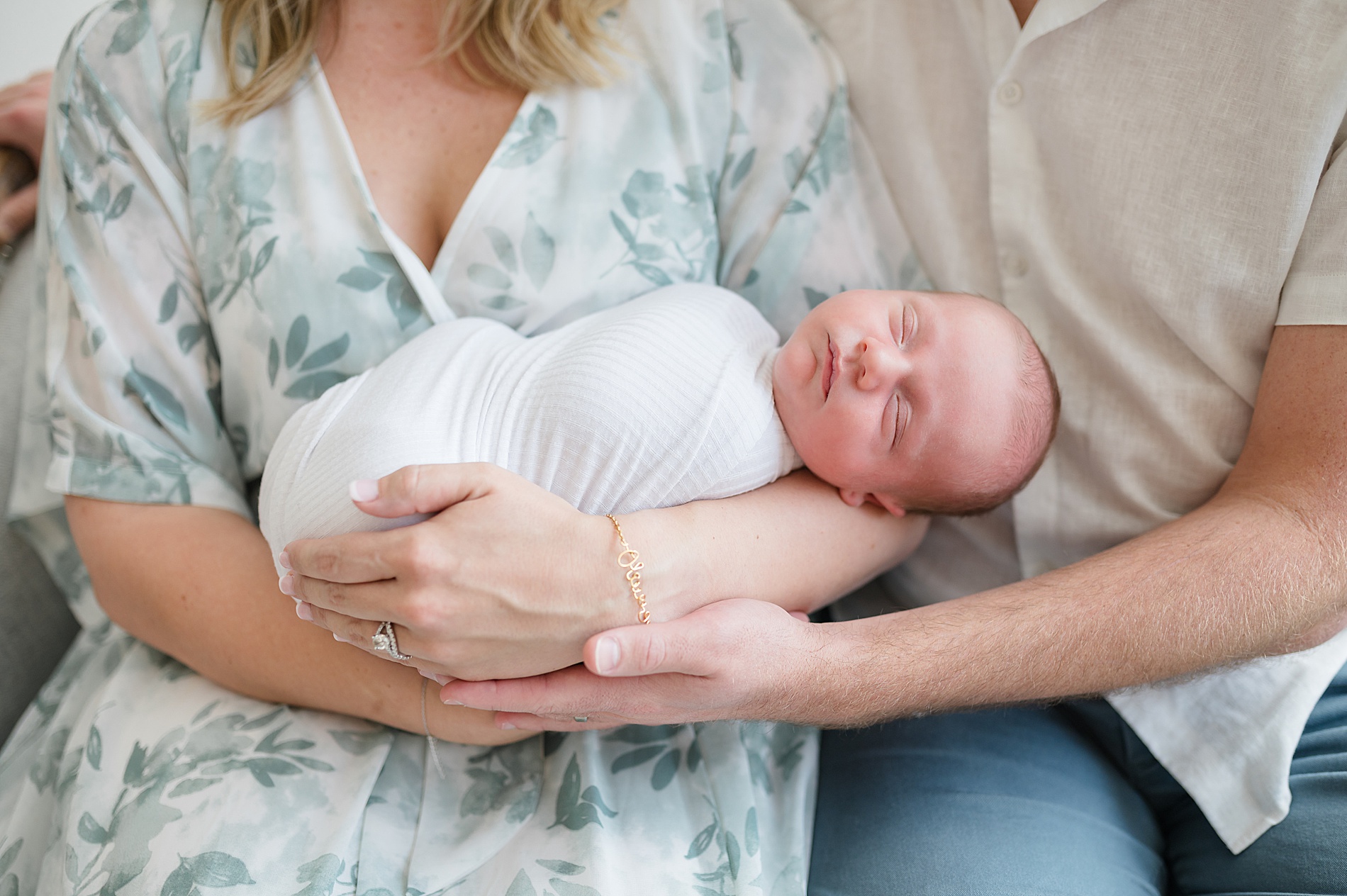 parents hold swaddled newborn