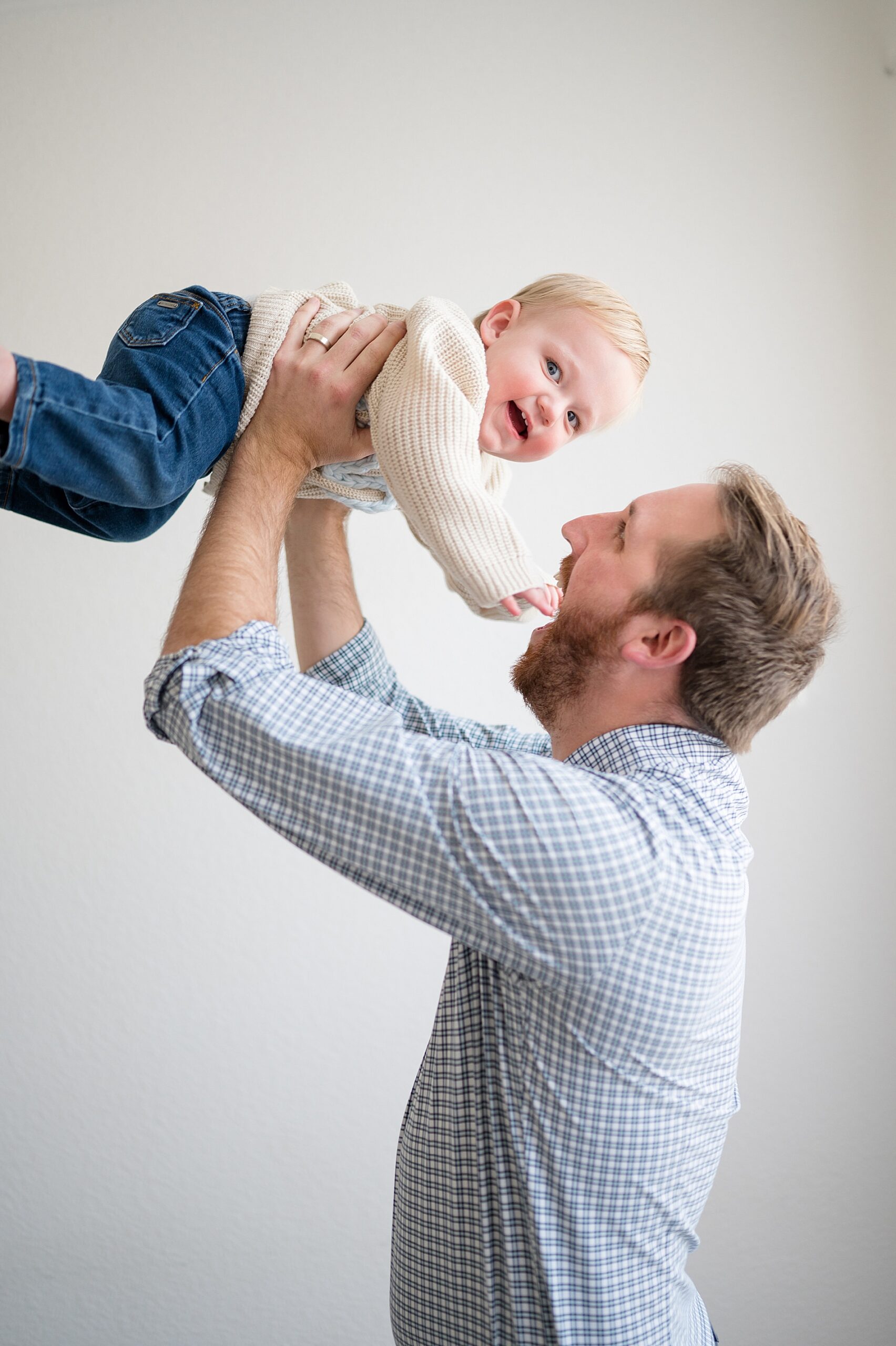 dad lifts one year old up in the air
