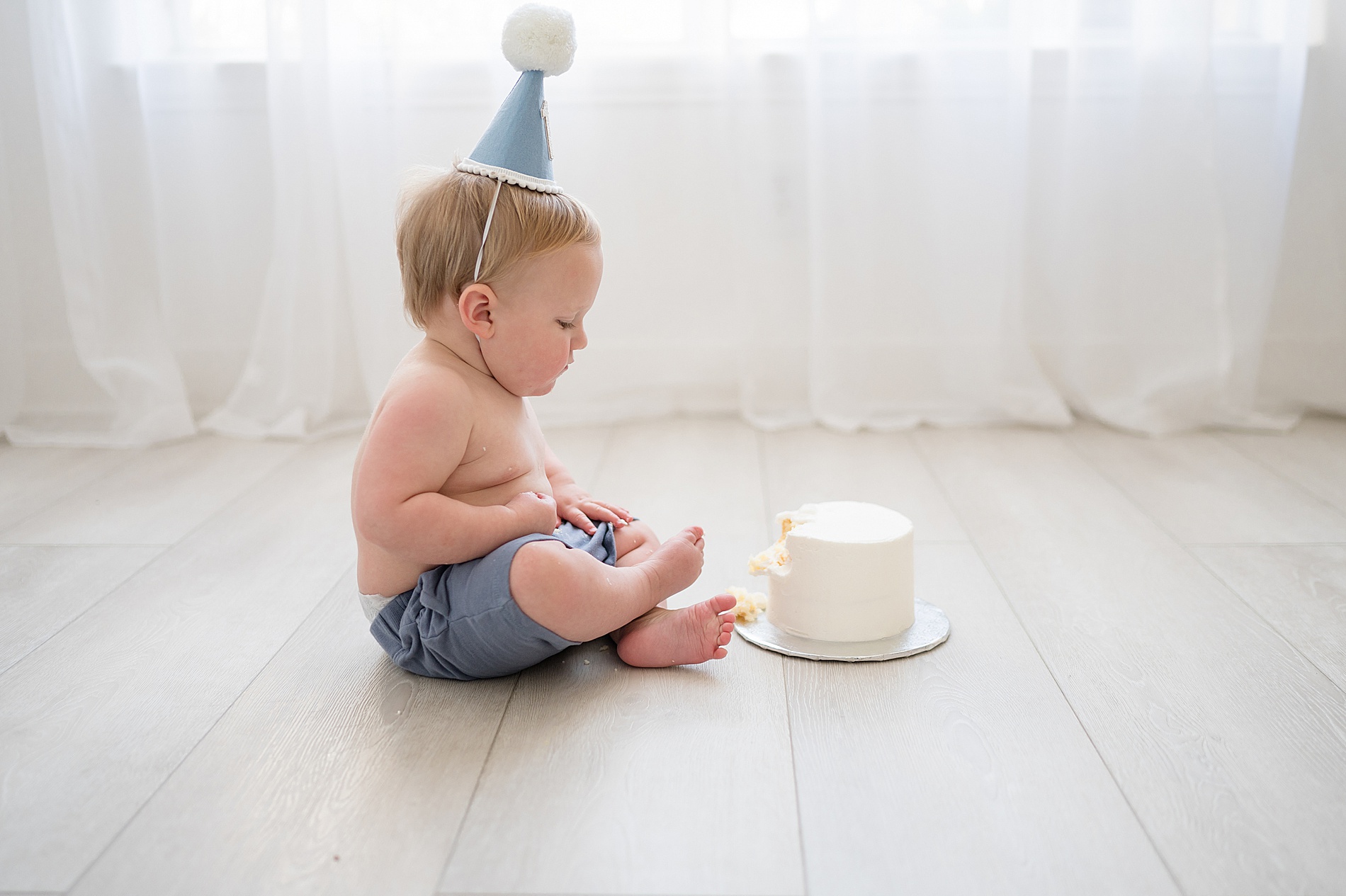 little boy looks at white cake