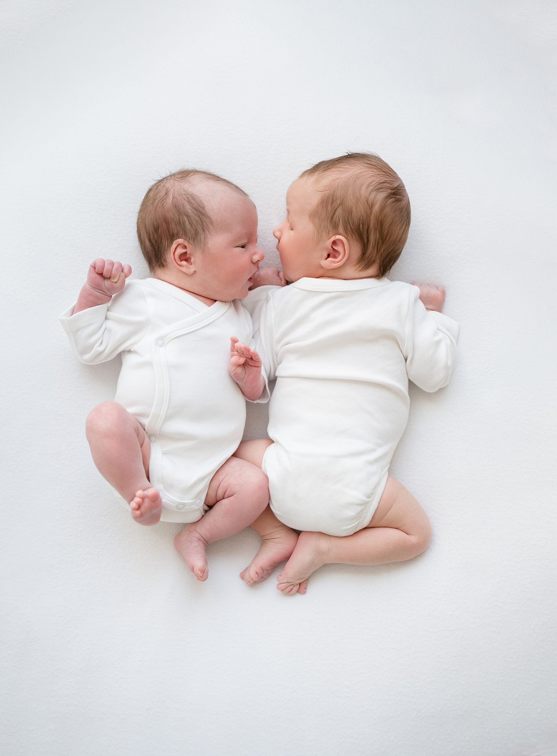 Baby-Led Twin Newborn Session in Texas Studio with one twin laying on tummy and one on their back