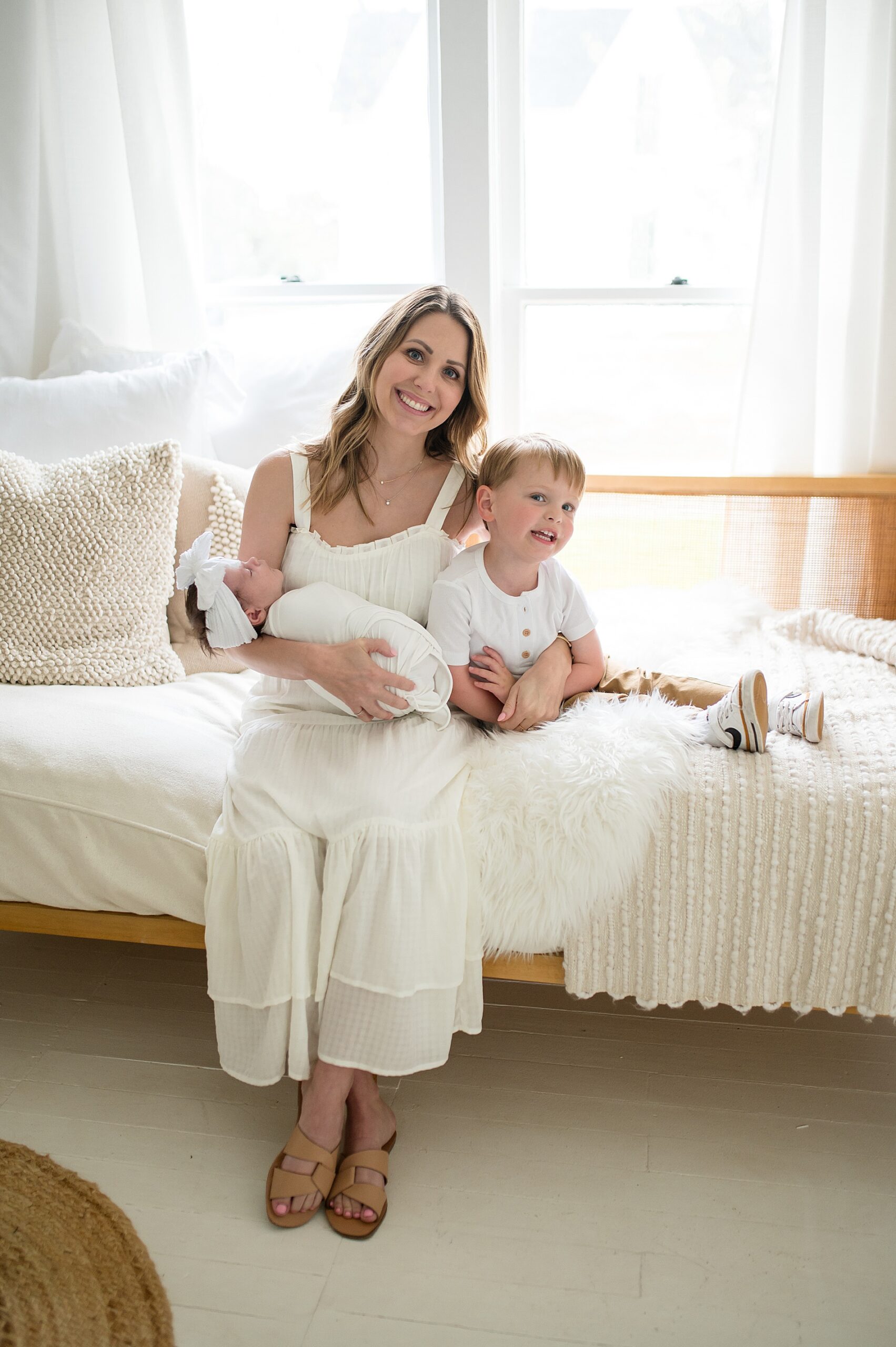 mom sits with son while holding newborn girl 