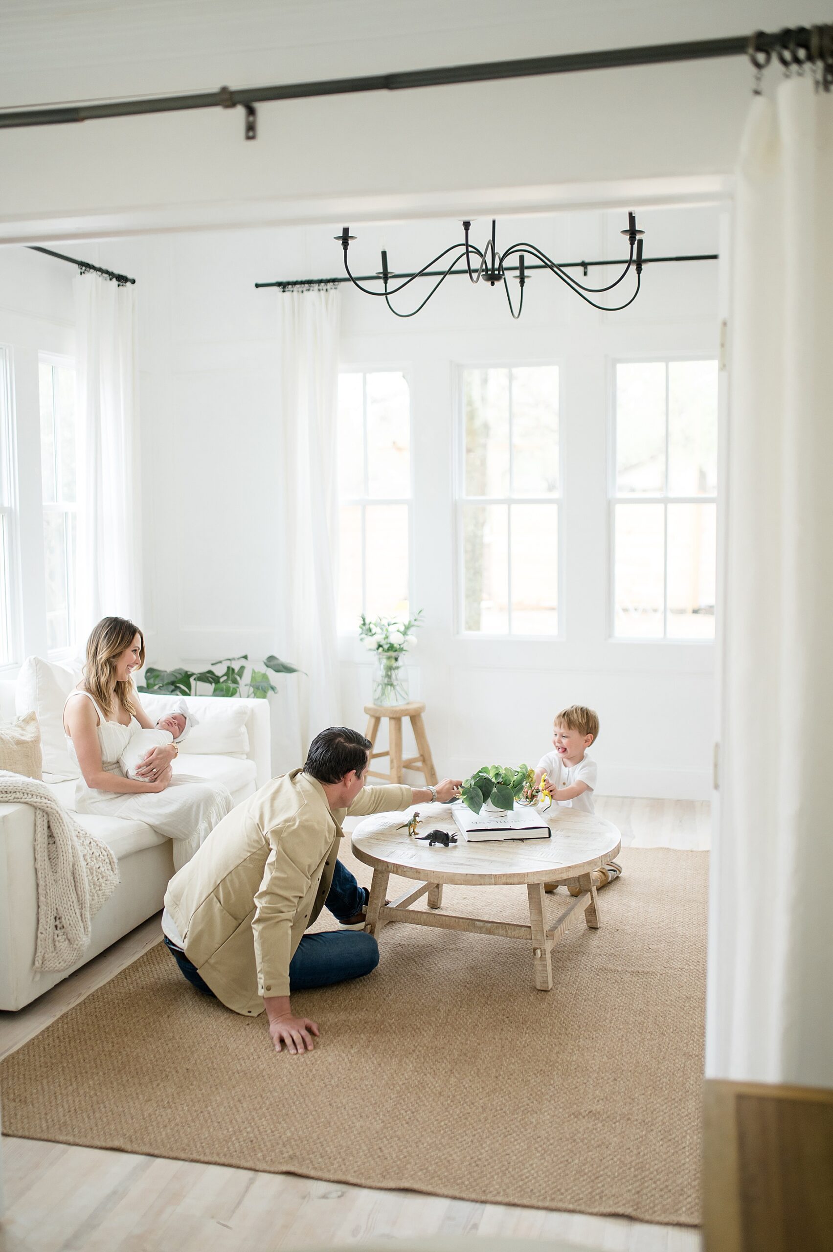 family sits in living room area of Beverly-Harris House during McKinney, TX Newborn Session