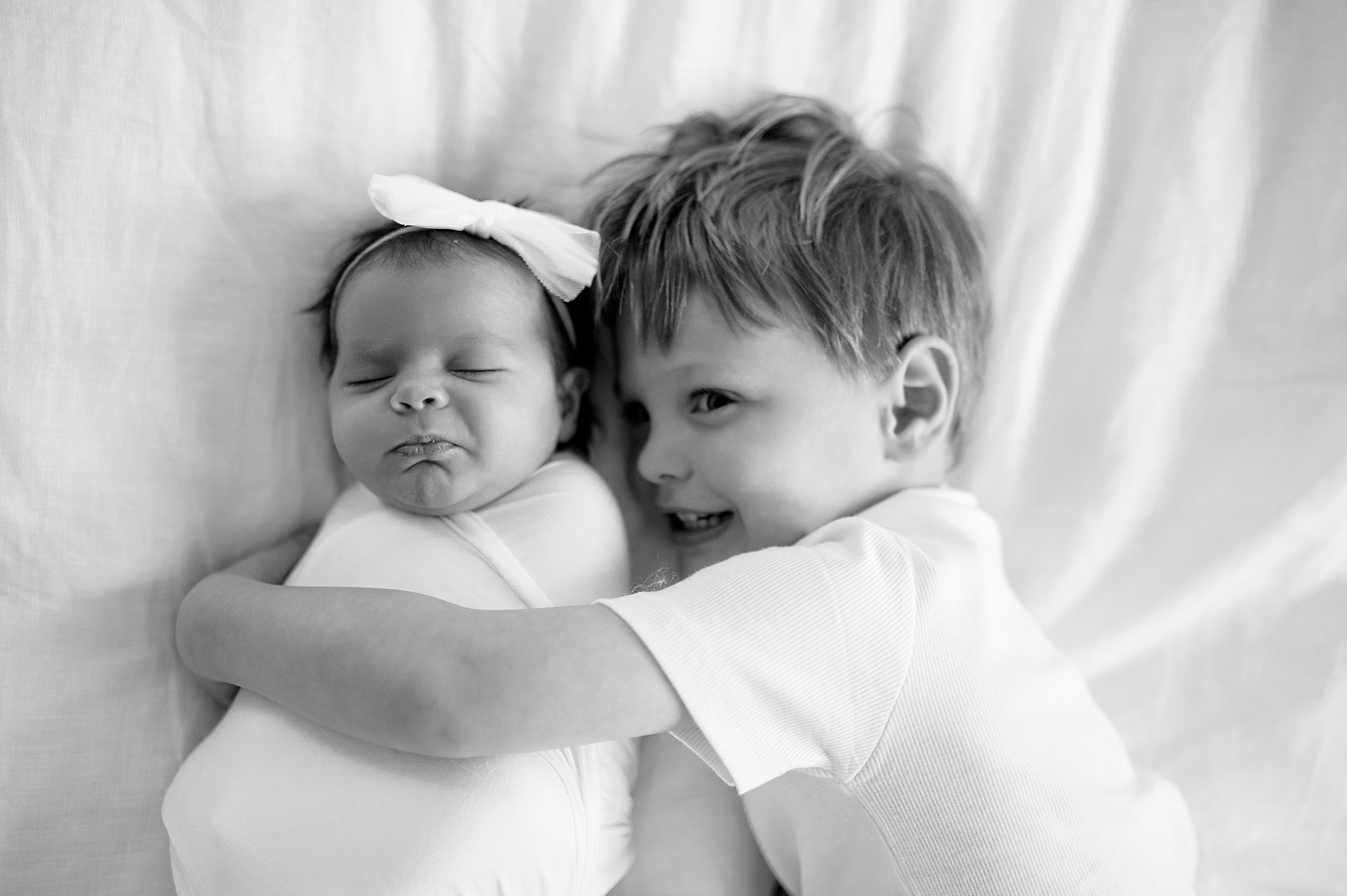 big brother hugs newborn sister during Beverly-Harris House Newborn Session