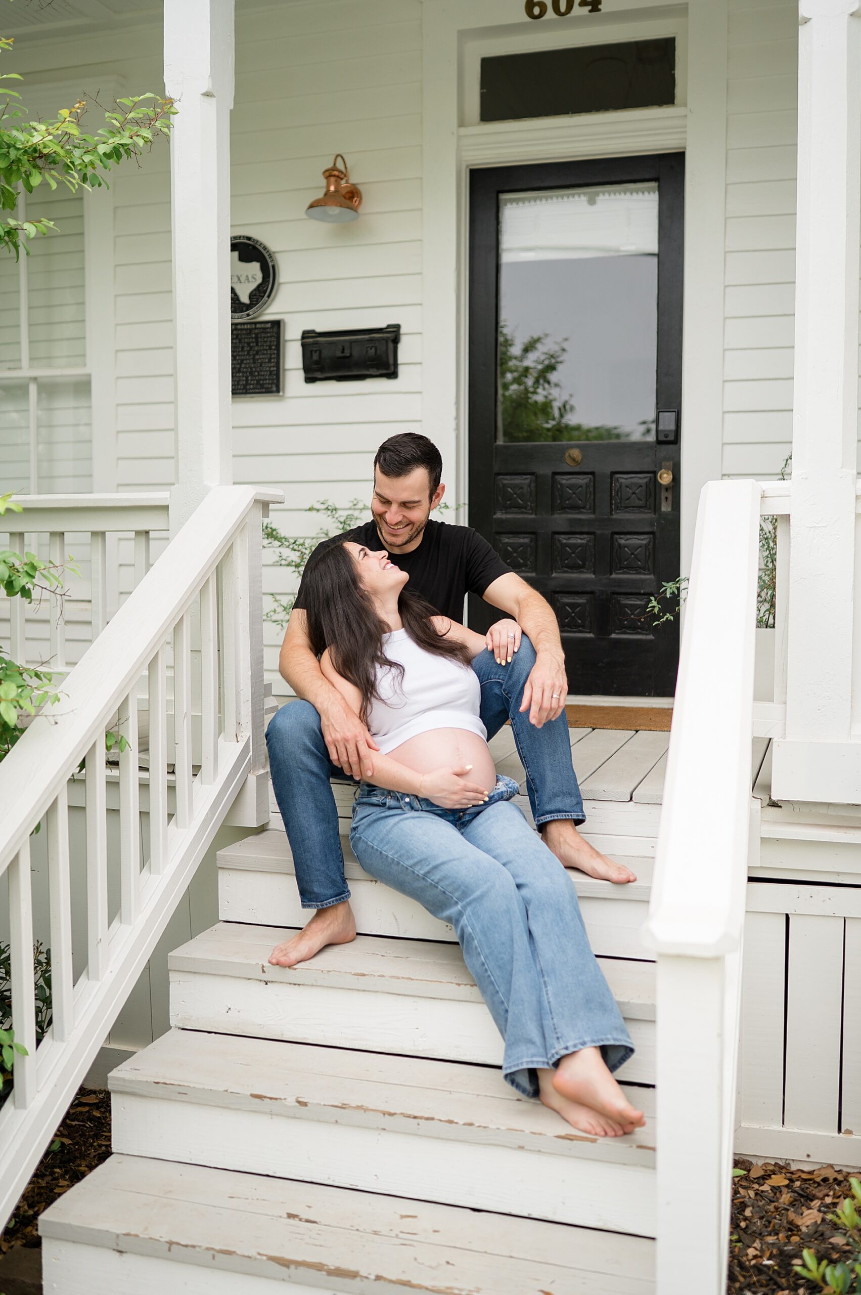 couple sit on porch stairs | The Best Time to Book Maternity Photos by Dallas Maternity Photographer