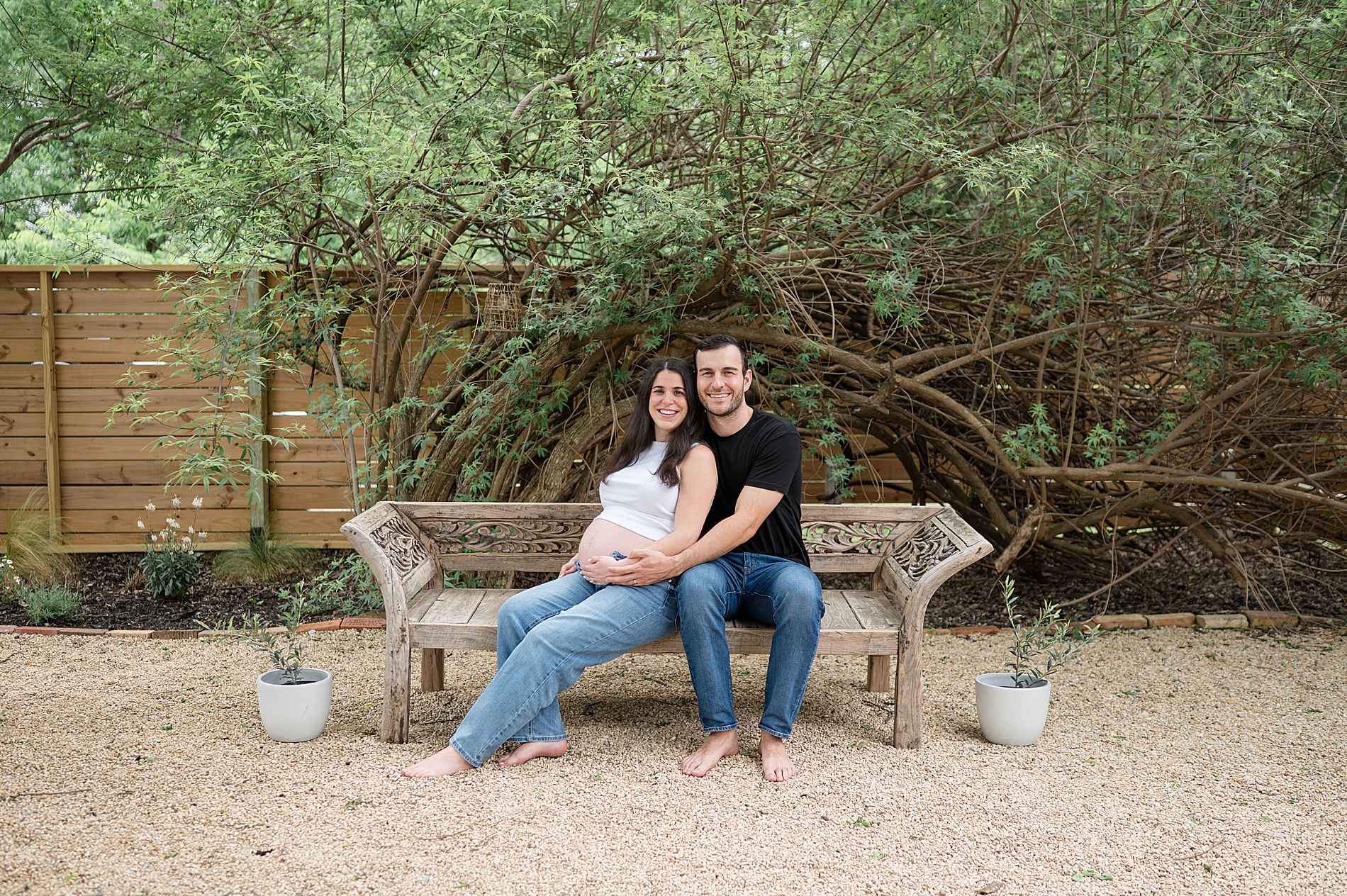 expectant parents sit on bench