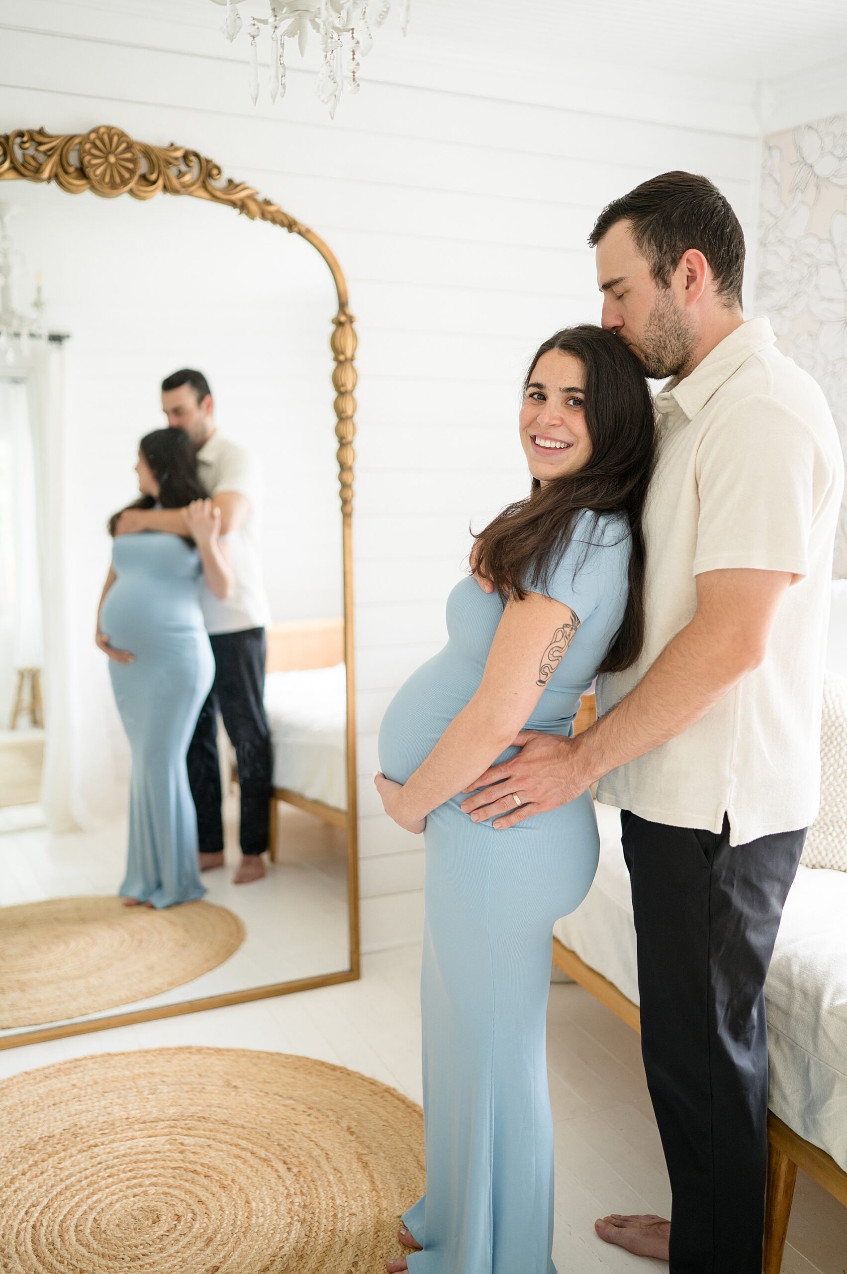 couple stand in front of mirror during maternity session