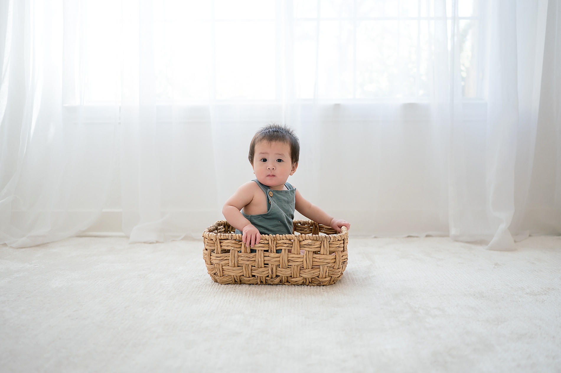 little boy sits in basket by One Year Milestone Photographer