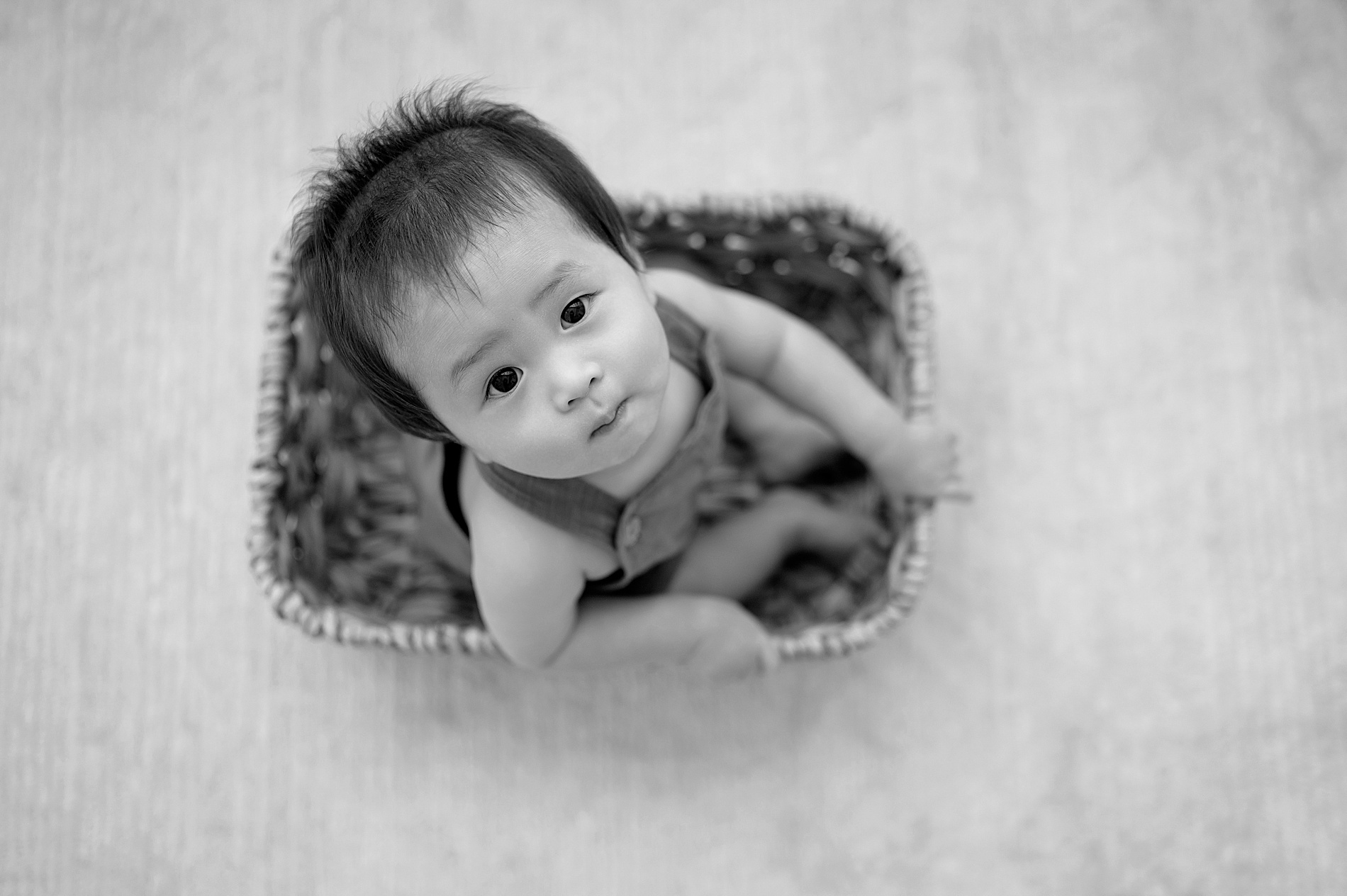 little boy in basket looks up