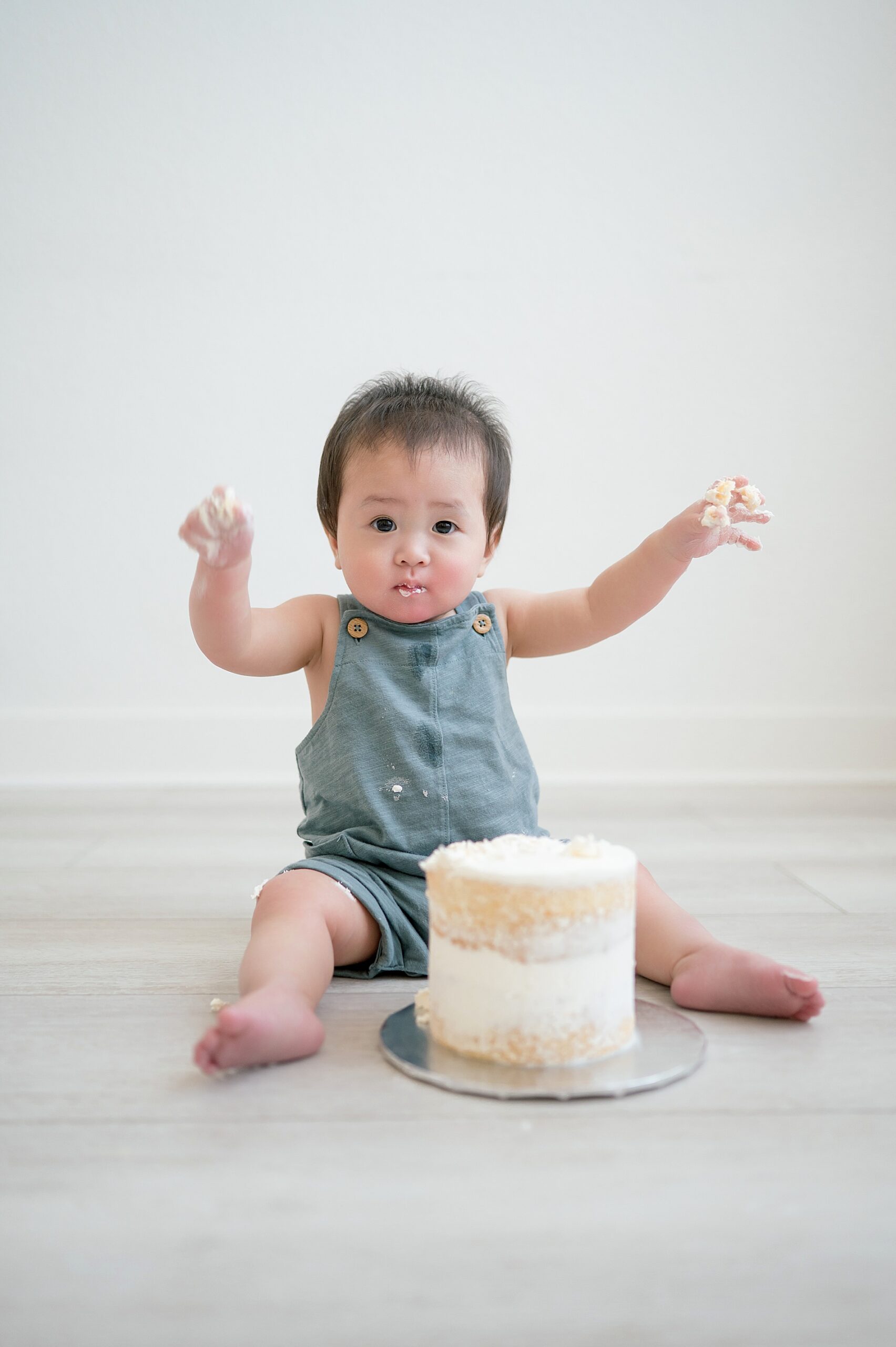 little boy poked at cake during First Birthday Cake Smash Session