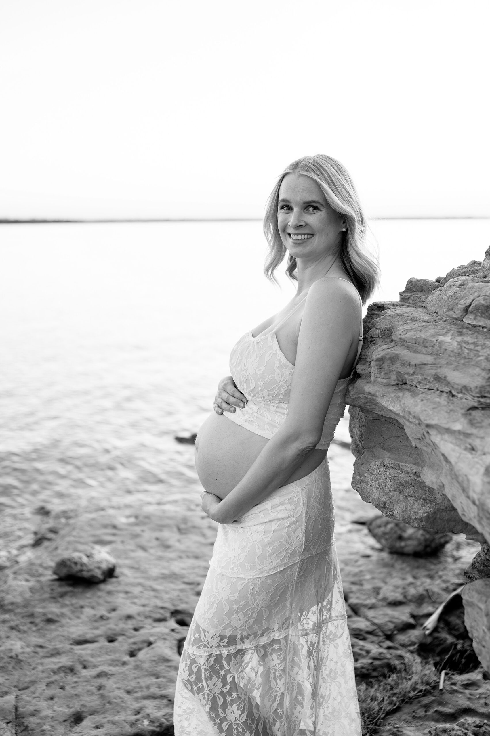 maternity portraits of woman leaning against rock ledge