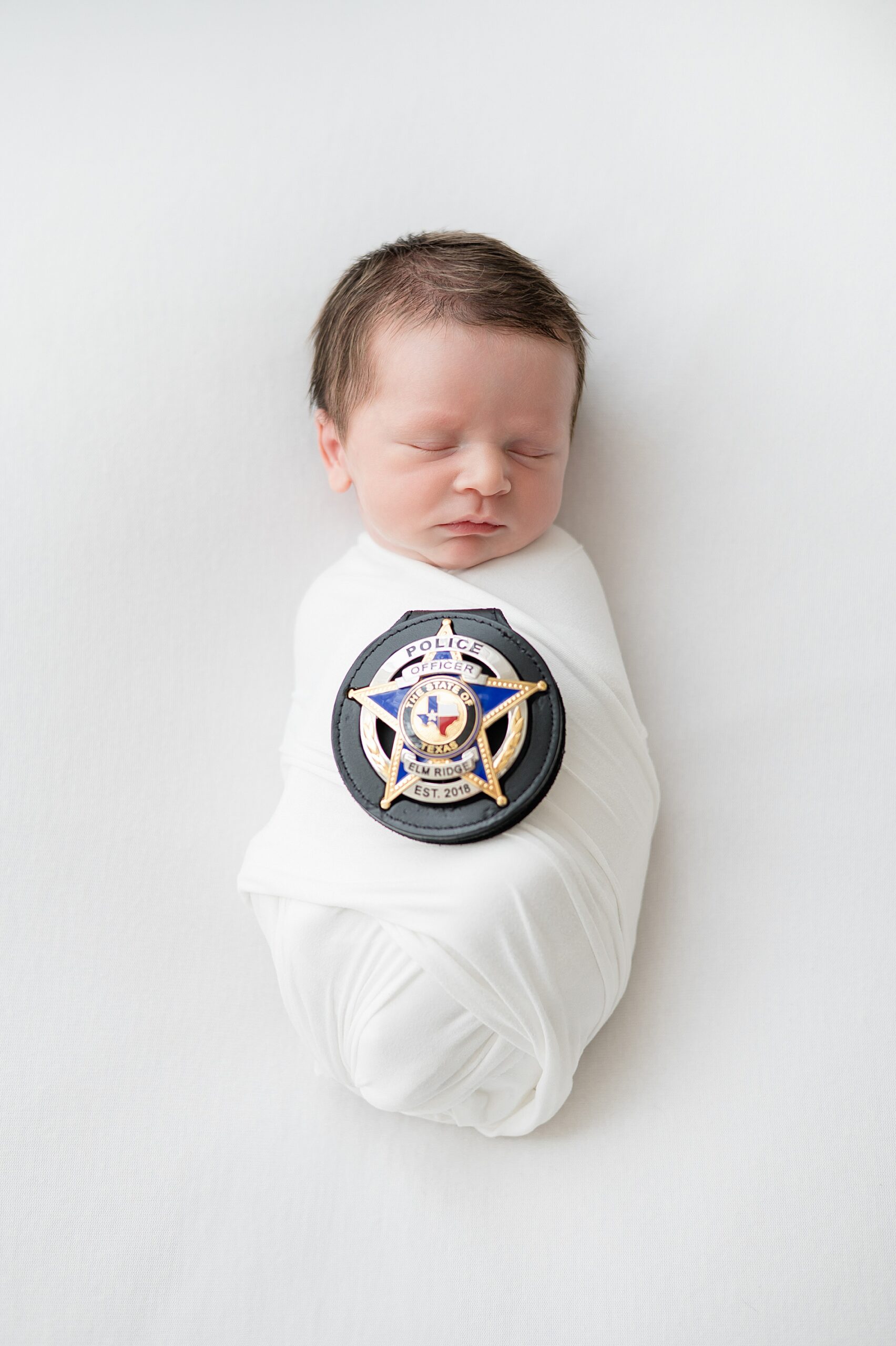 newborn sleeps with dad's police badge