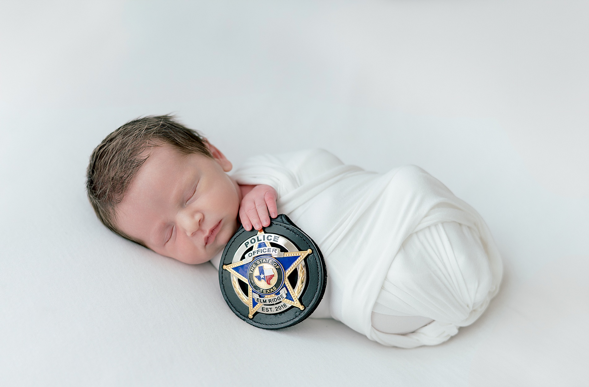 newborn photography with dad's police badge