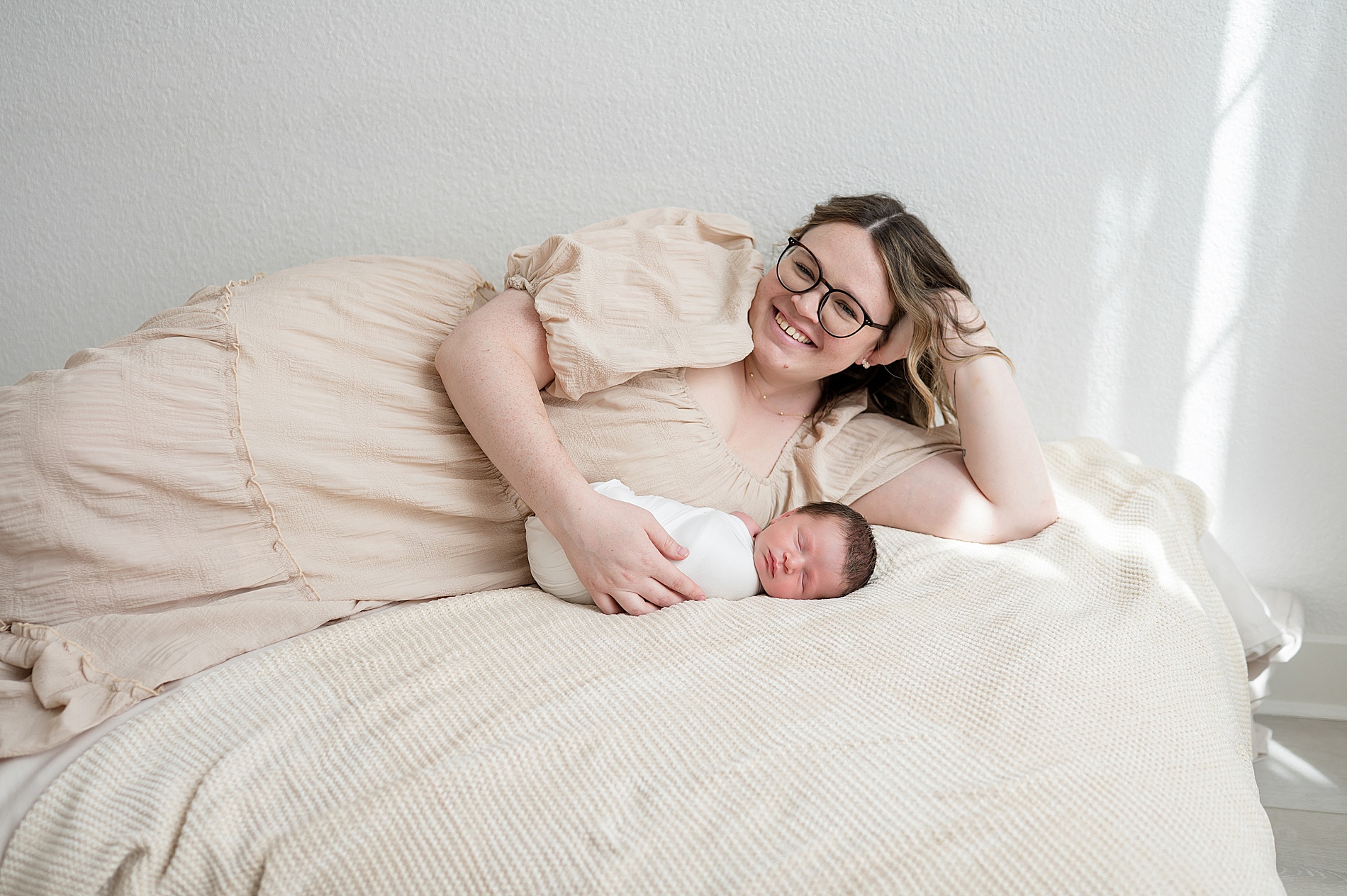 mom lays with newborn boy