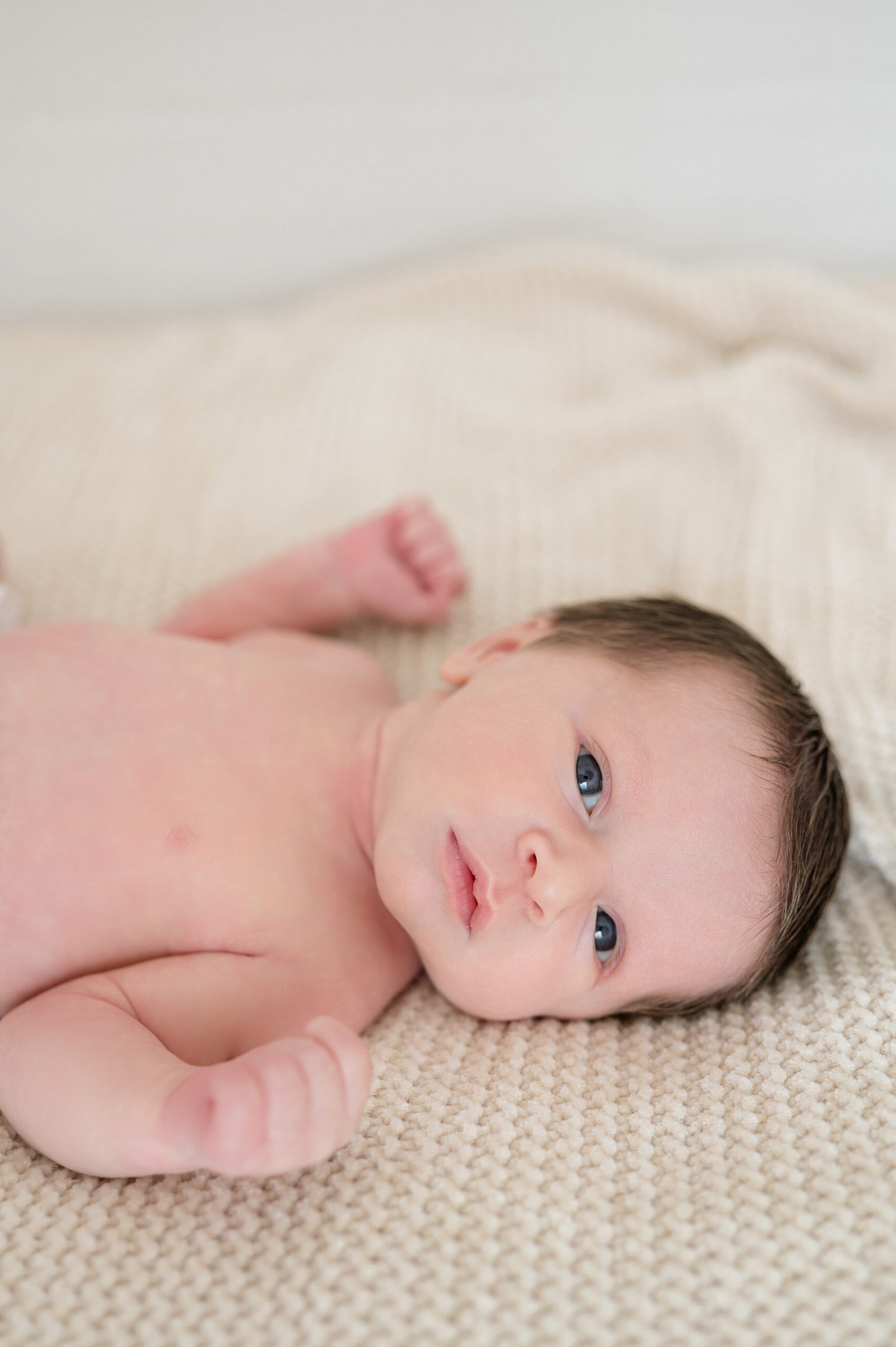 newborn boy is wide-eyed during newborn session at Dallas studio