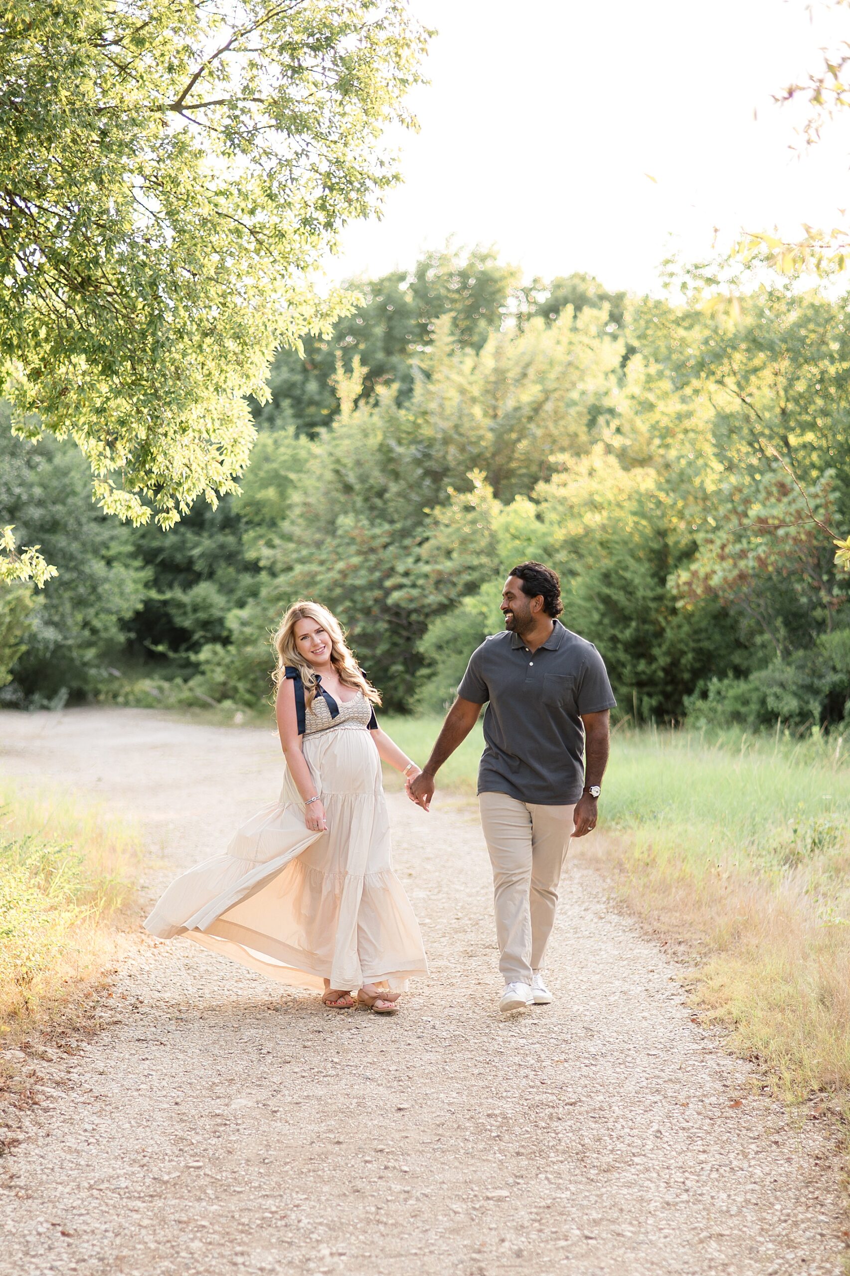 couple walk together on path during Golden Hour Maternity Session