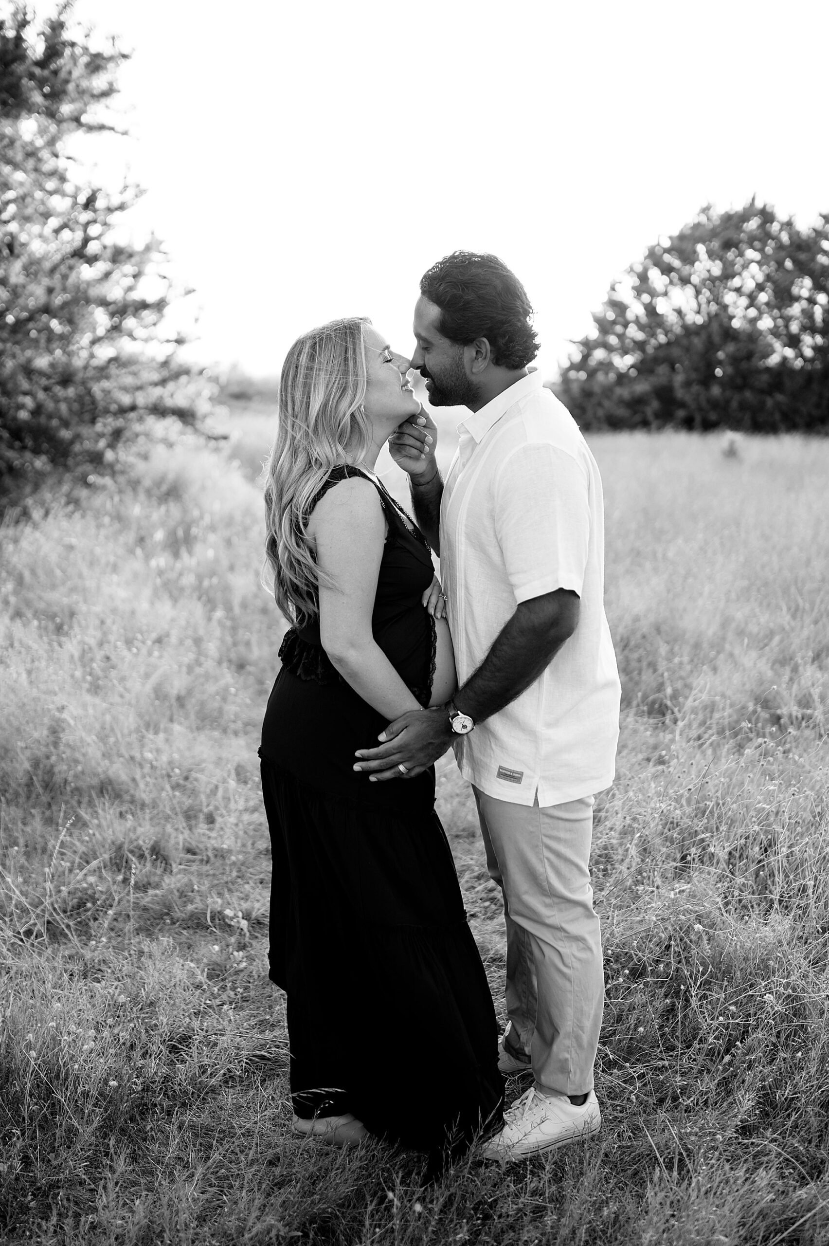 couple kiss during maternity session in Dallas
