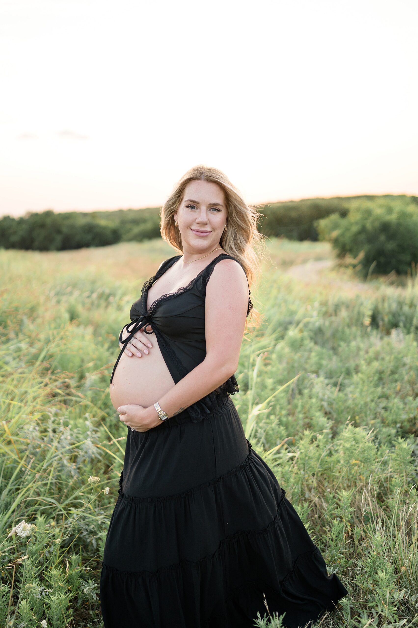 Dallas Maternity Session of woman in black two piece outfit showing off baby bump