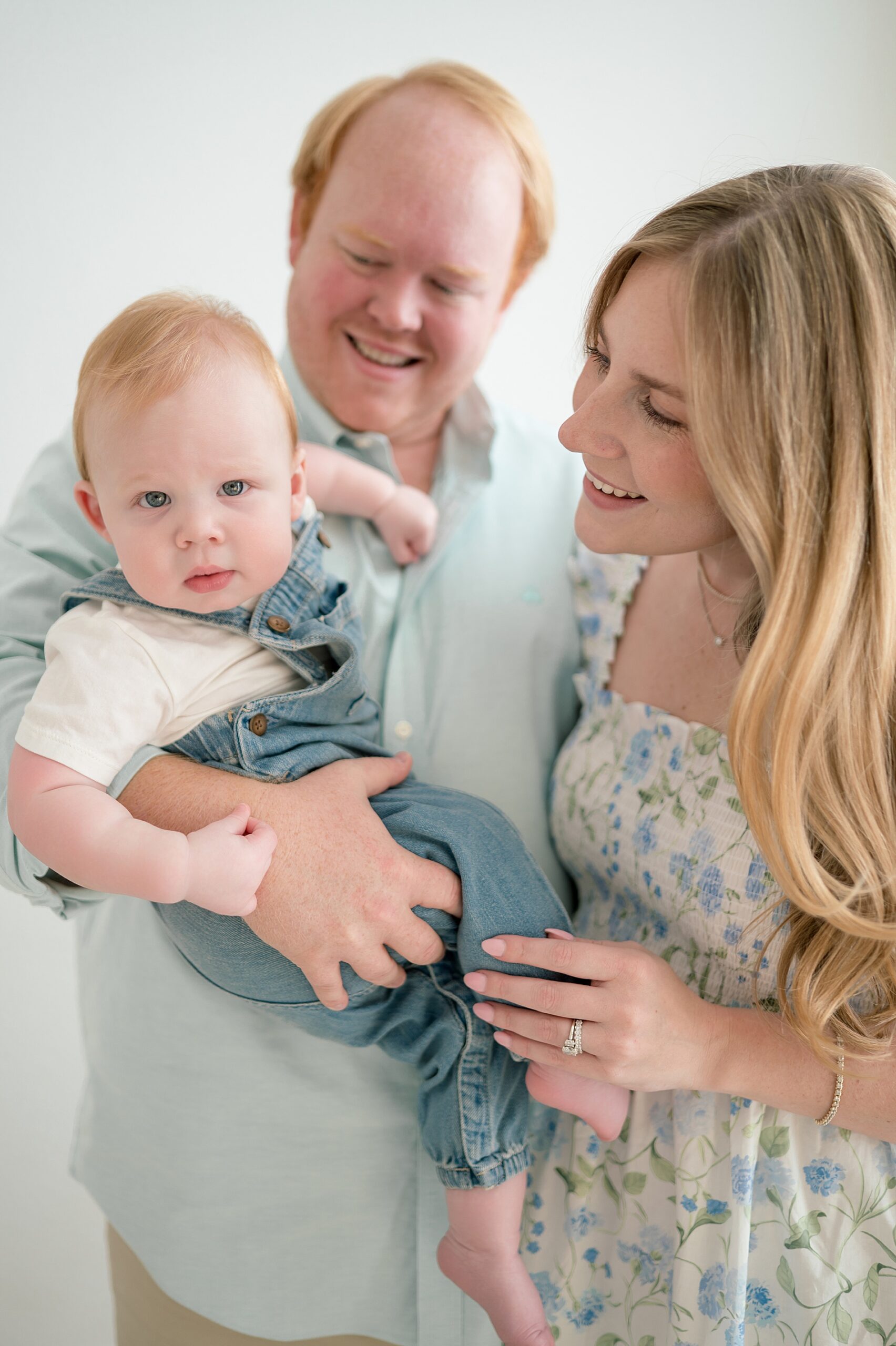 parents hold their one year old son 