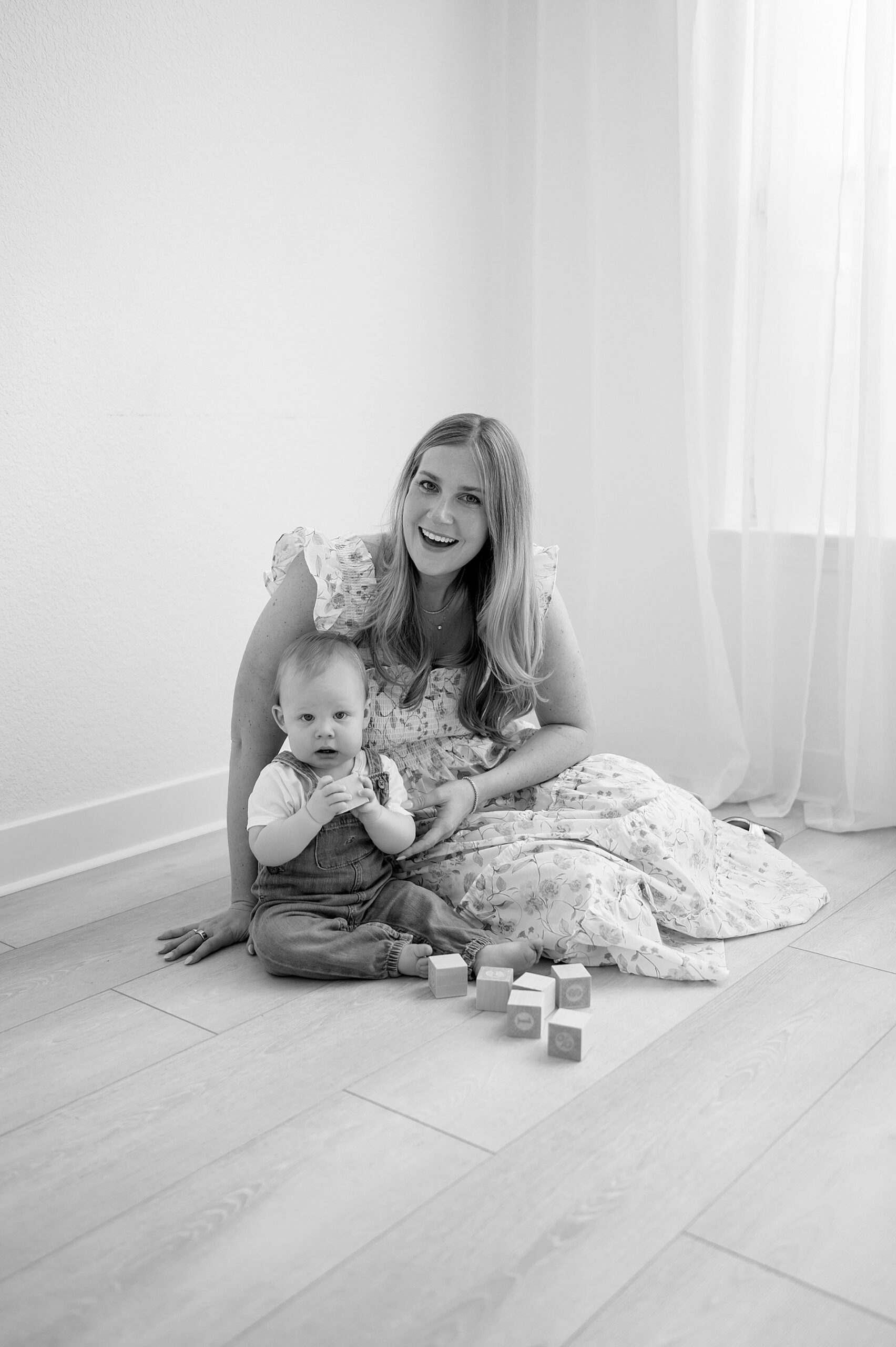 mom and son sit on floor playing with blocks