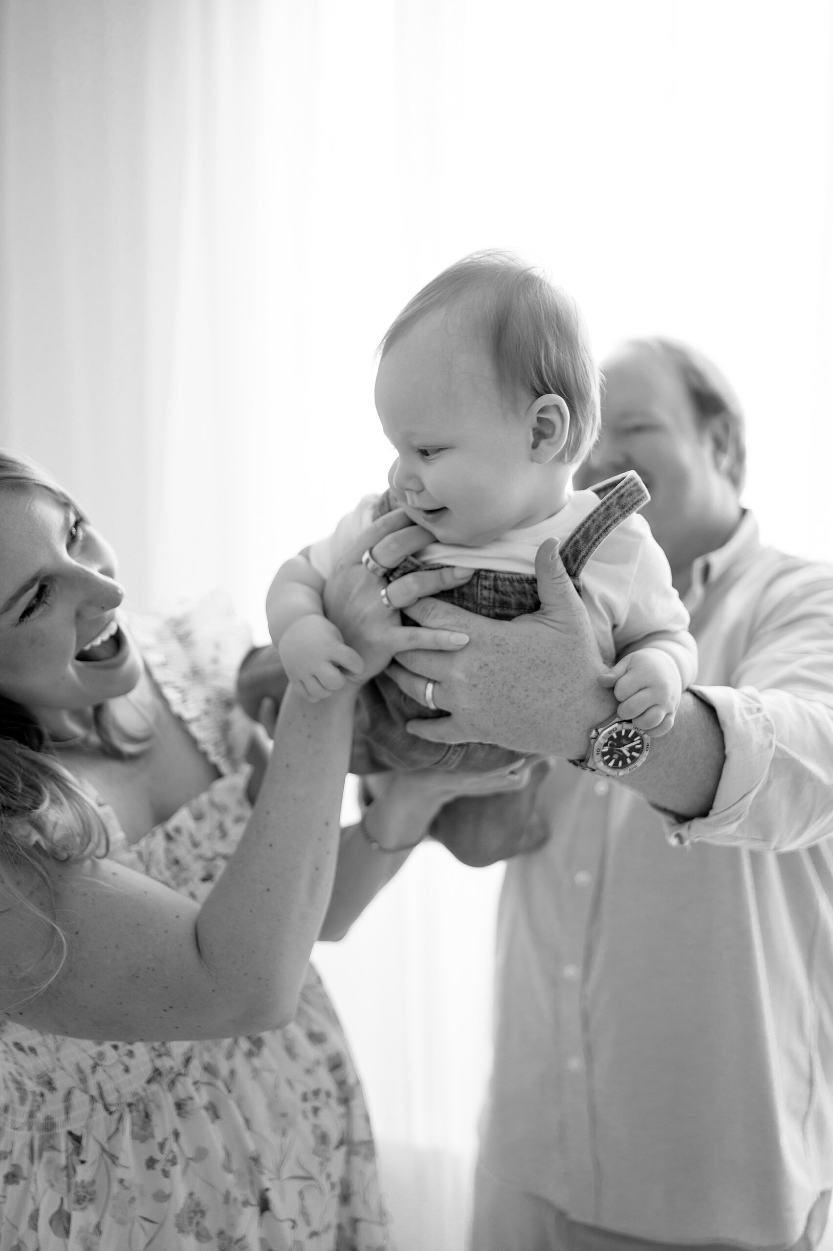 parents hold their son up in the air 