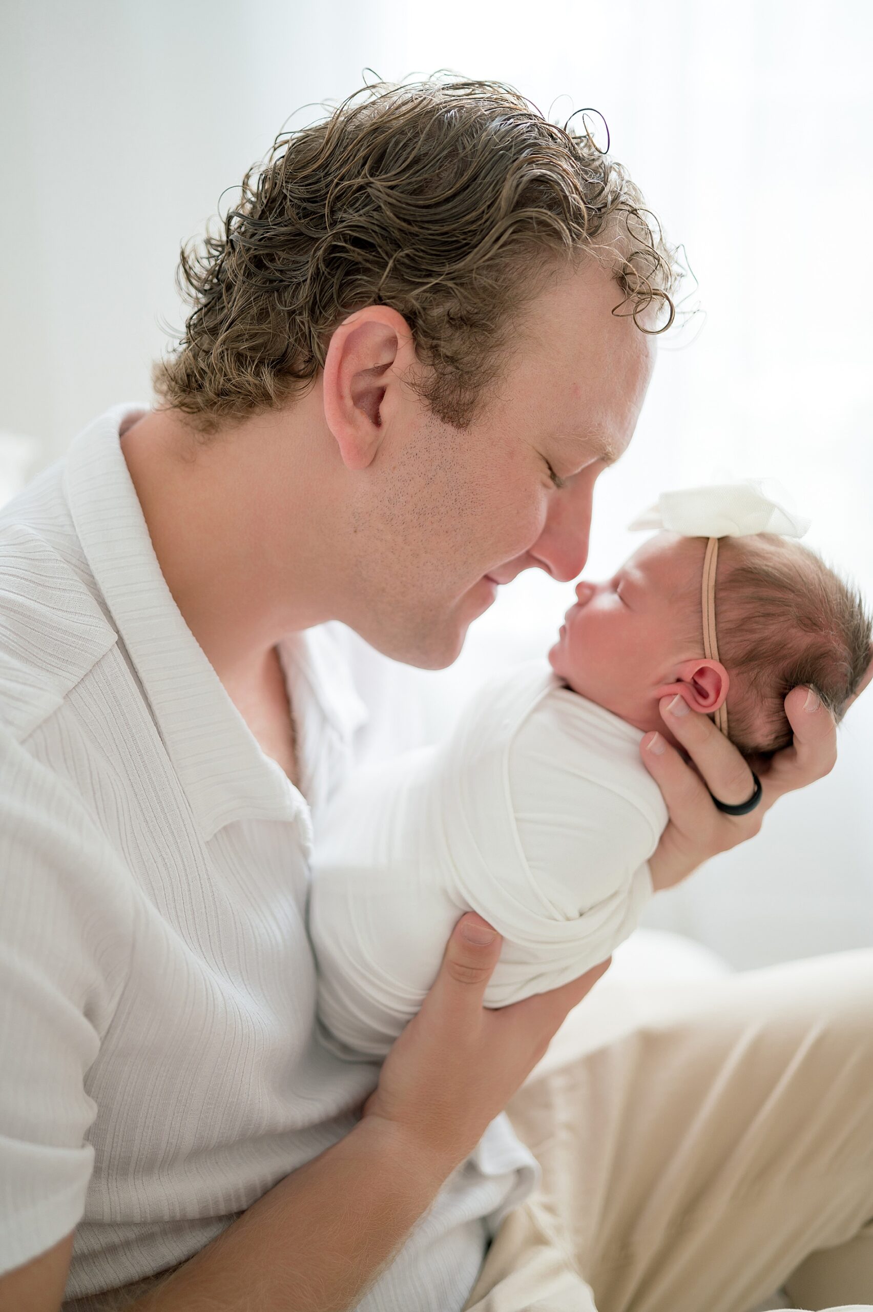 dad touches nose to newborn girl