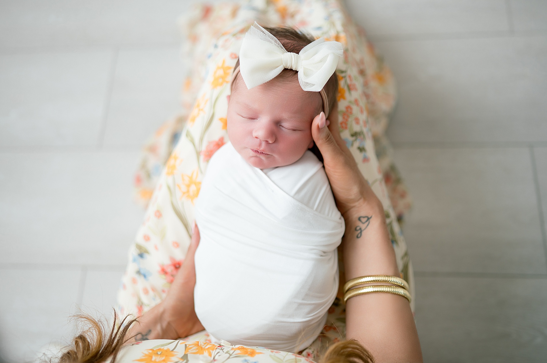 mom looks down at newborn sleeping in her lap