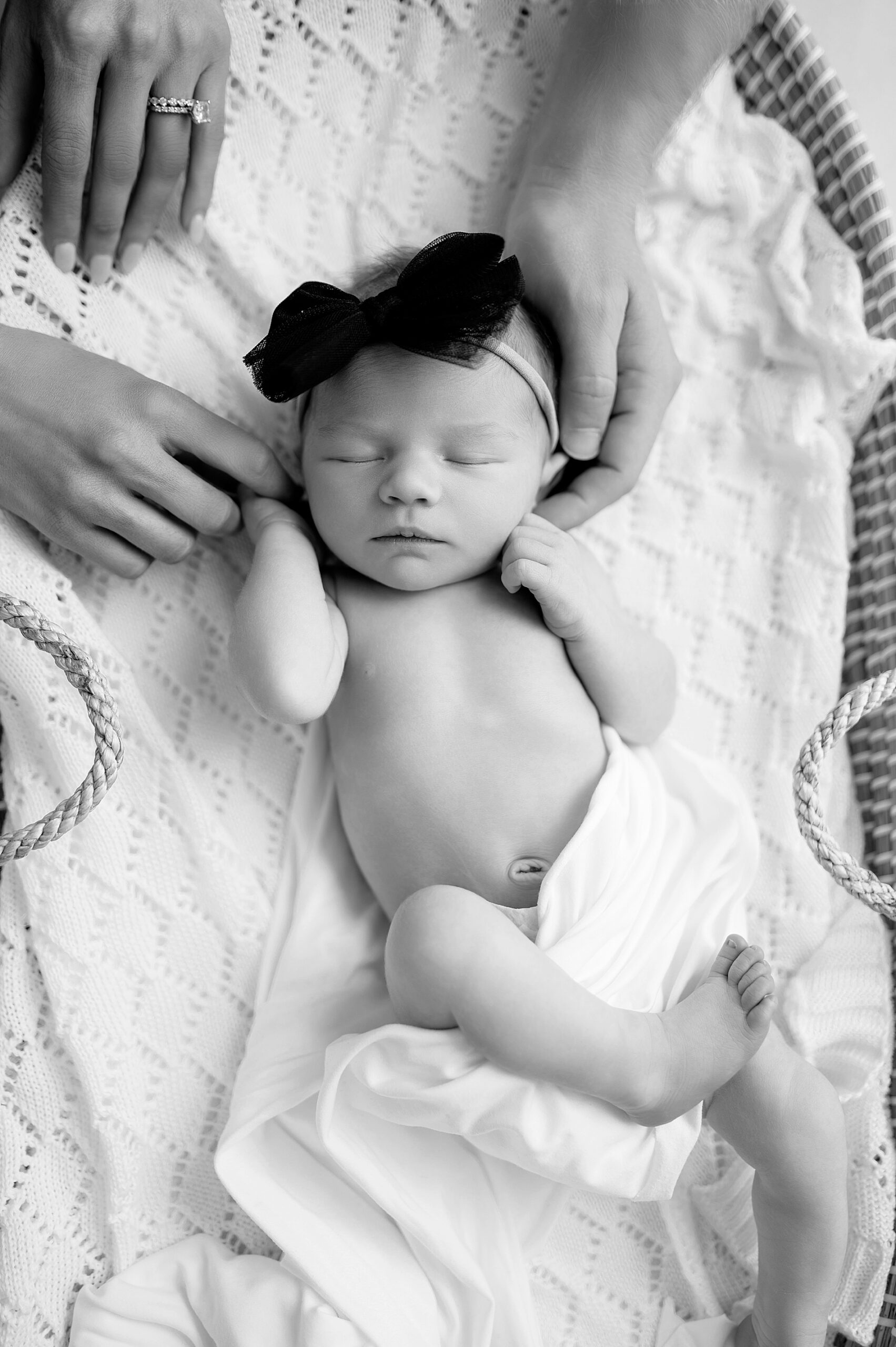 parents hands wrap around sleeping baby