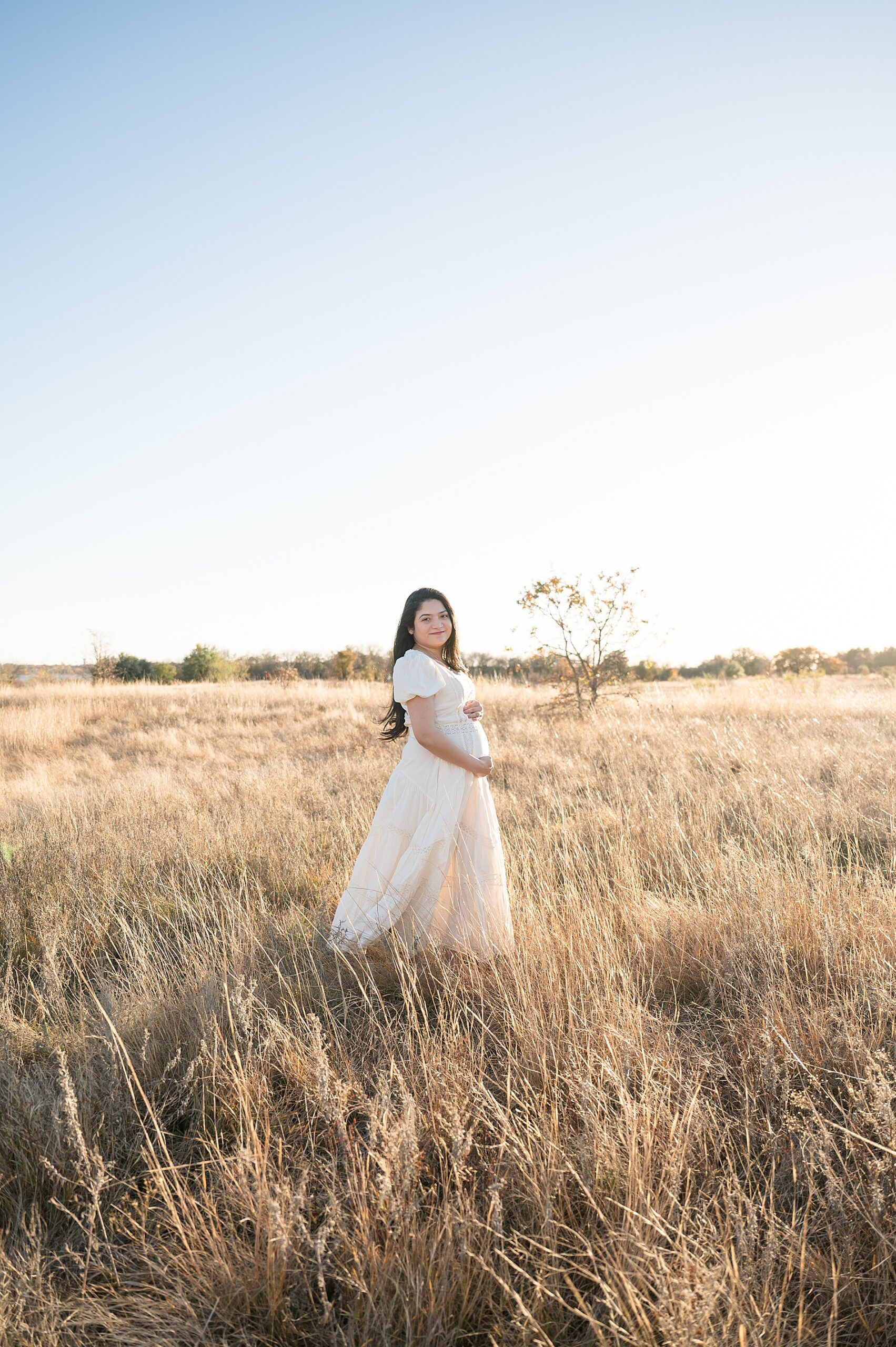 expectant mom in open field during golden hour in Flower Mound, TX