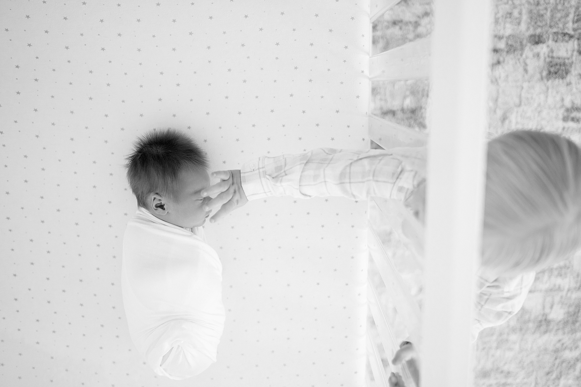 older sibling reaches in to touch newborn brother