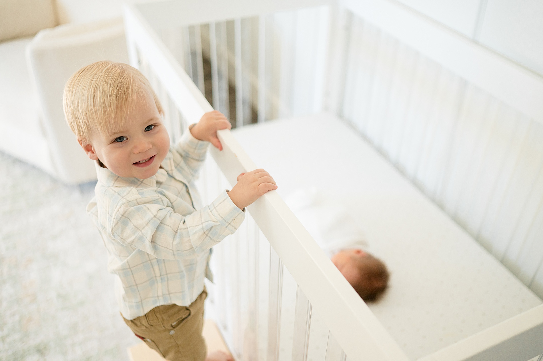 big brother watching baby brother sleep during in-home newborn session in Plano, TX