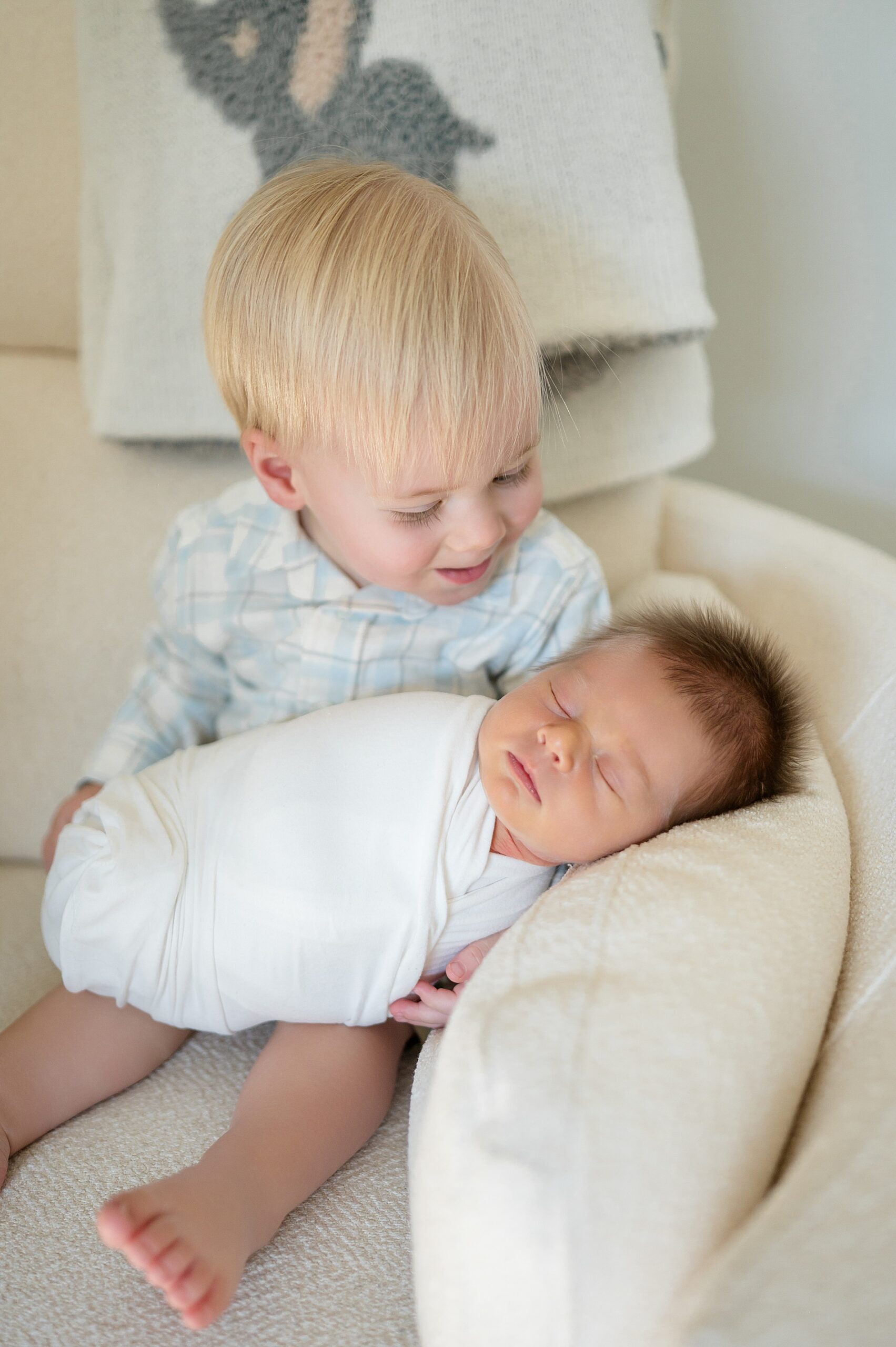 big brother looks lovingly at baby brother 