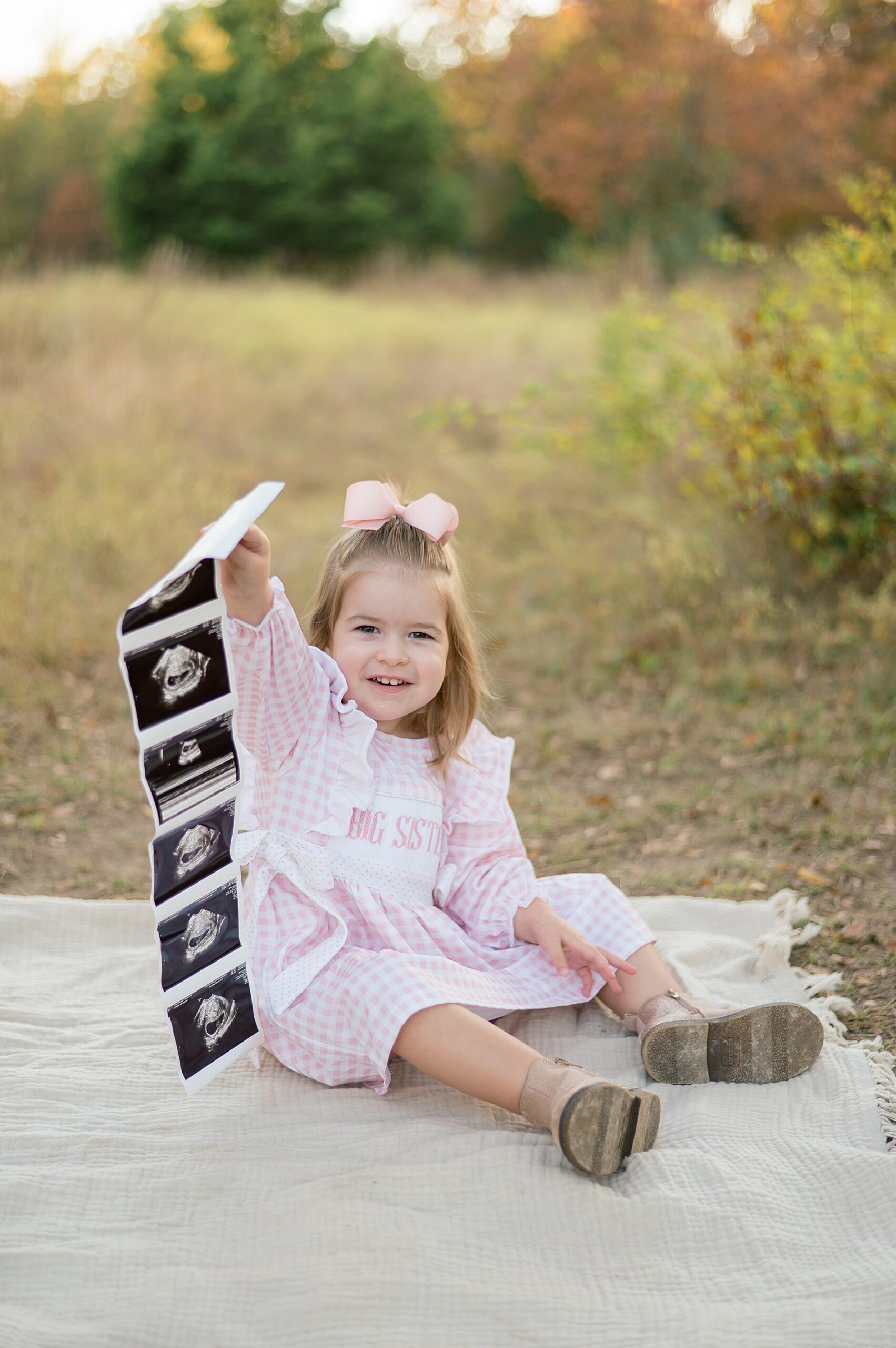 little girl hold up ultrasound photos 