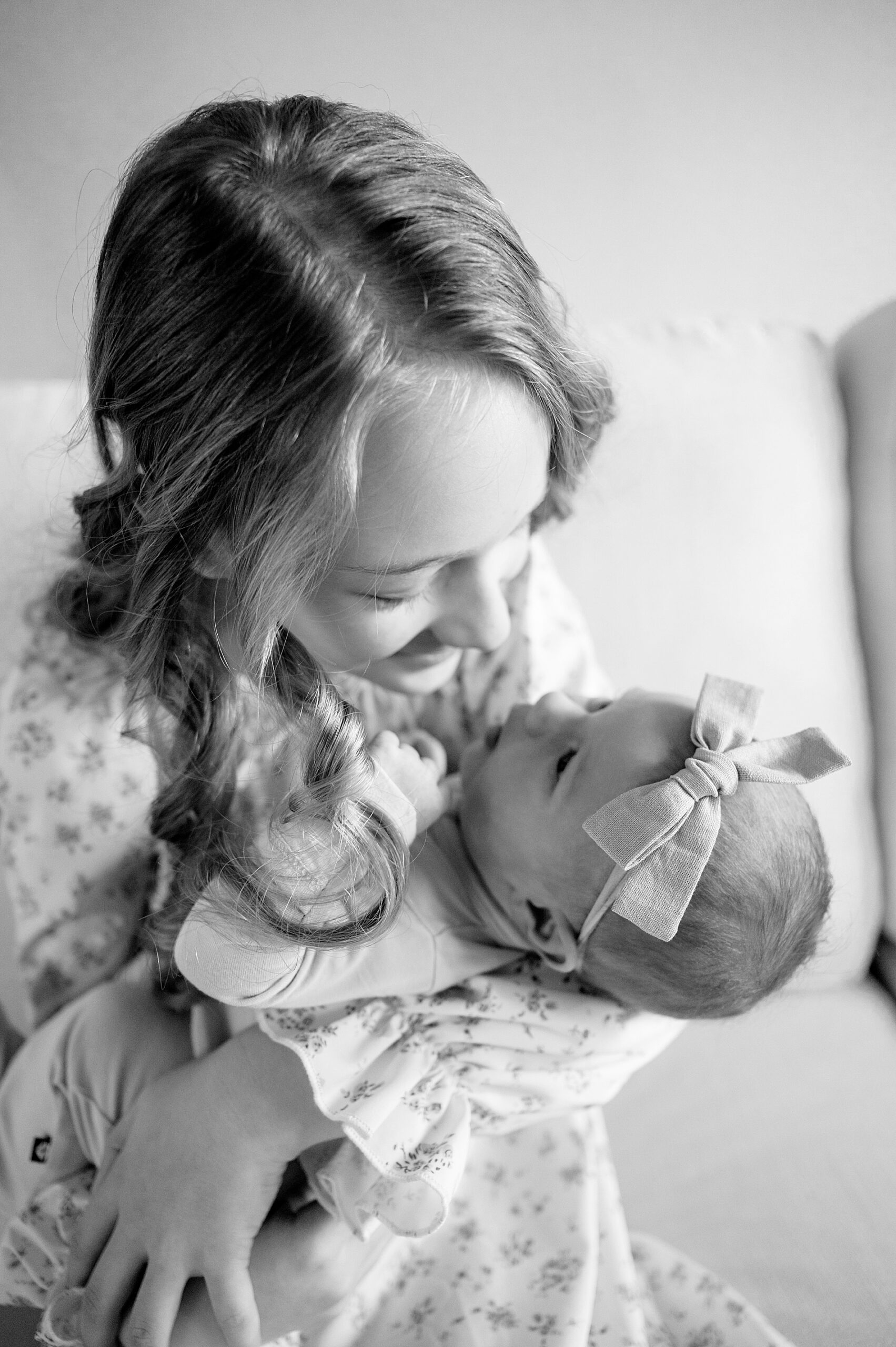 big sister looks down lovingly at newborn 