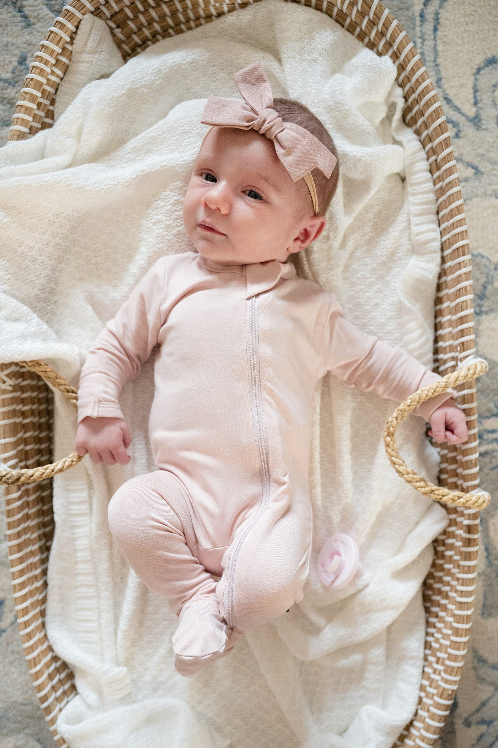 newborn girl in pink outfit and bow