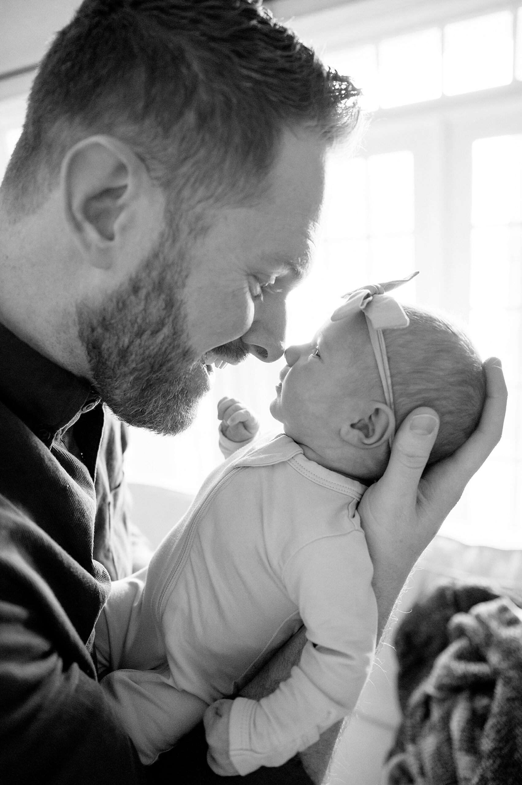 dad holds newborn daughter close to face 