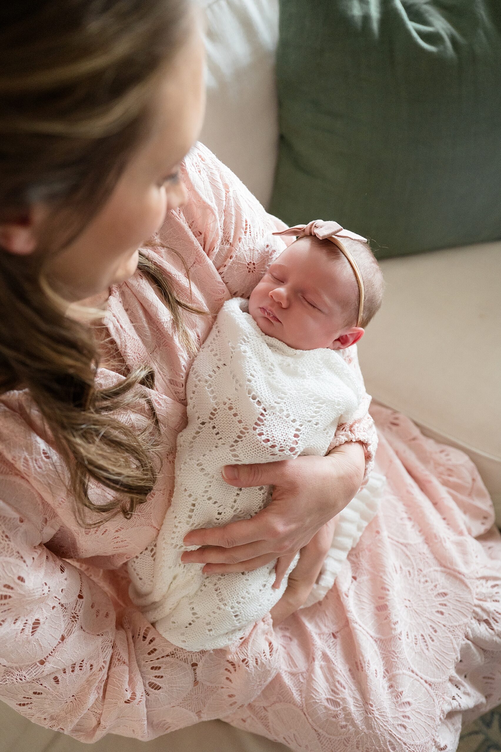 mom looks down lovingly at newborn girl 
