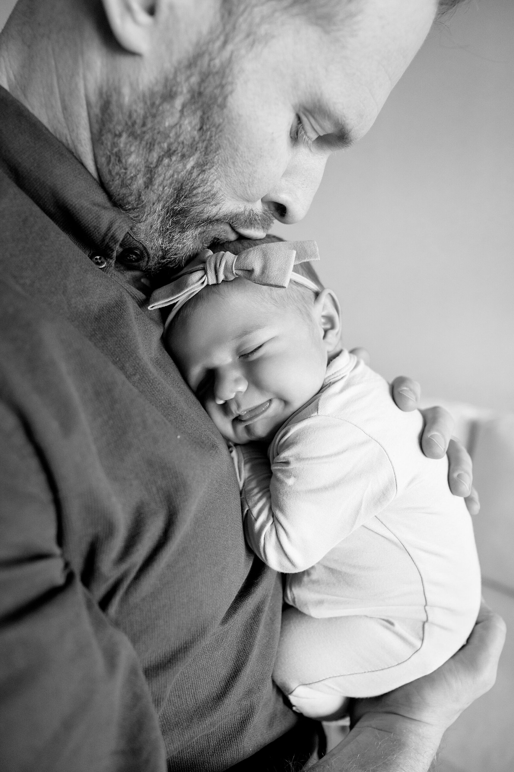 dad kisses newborn daughter's head