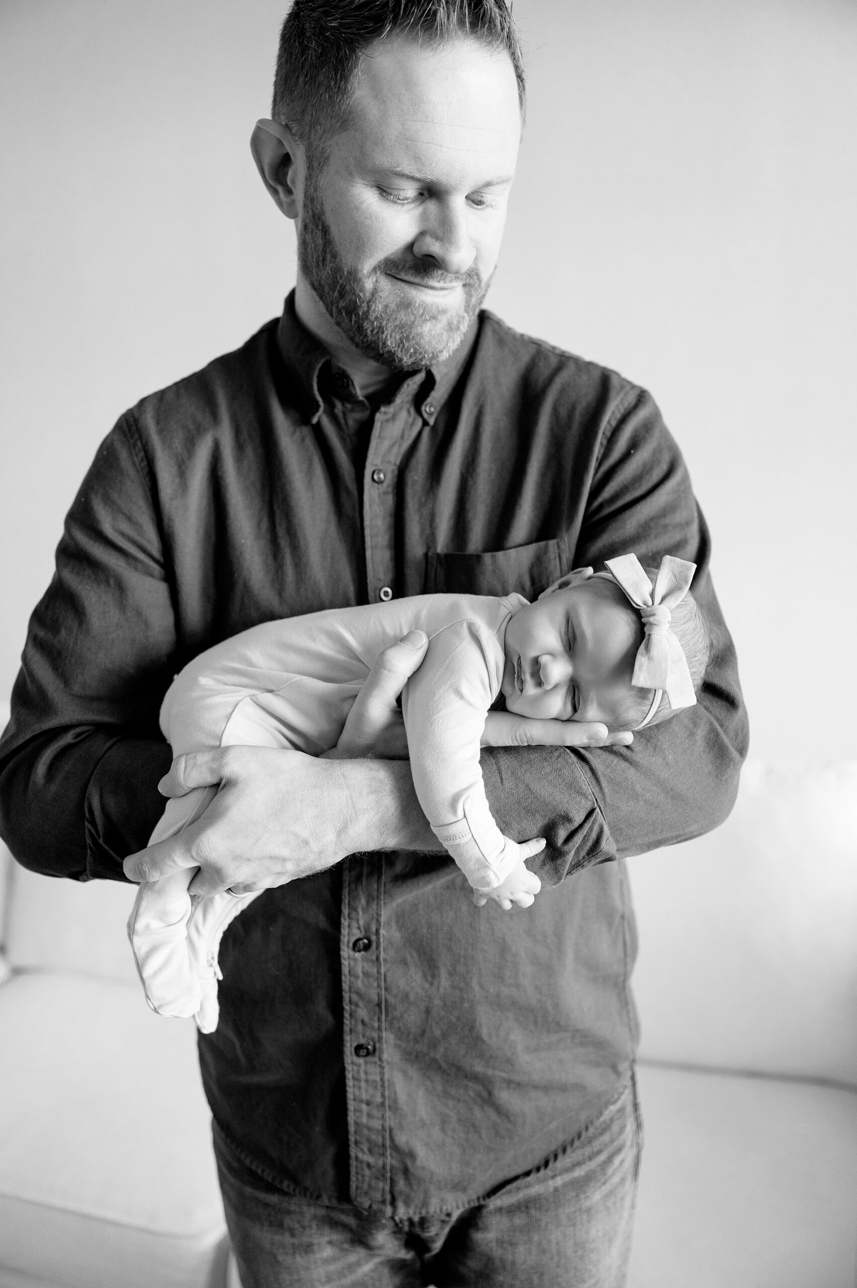 dad cradles newborn girl 