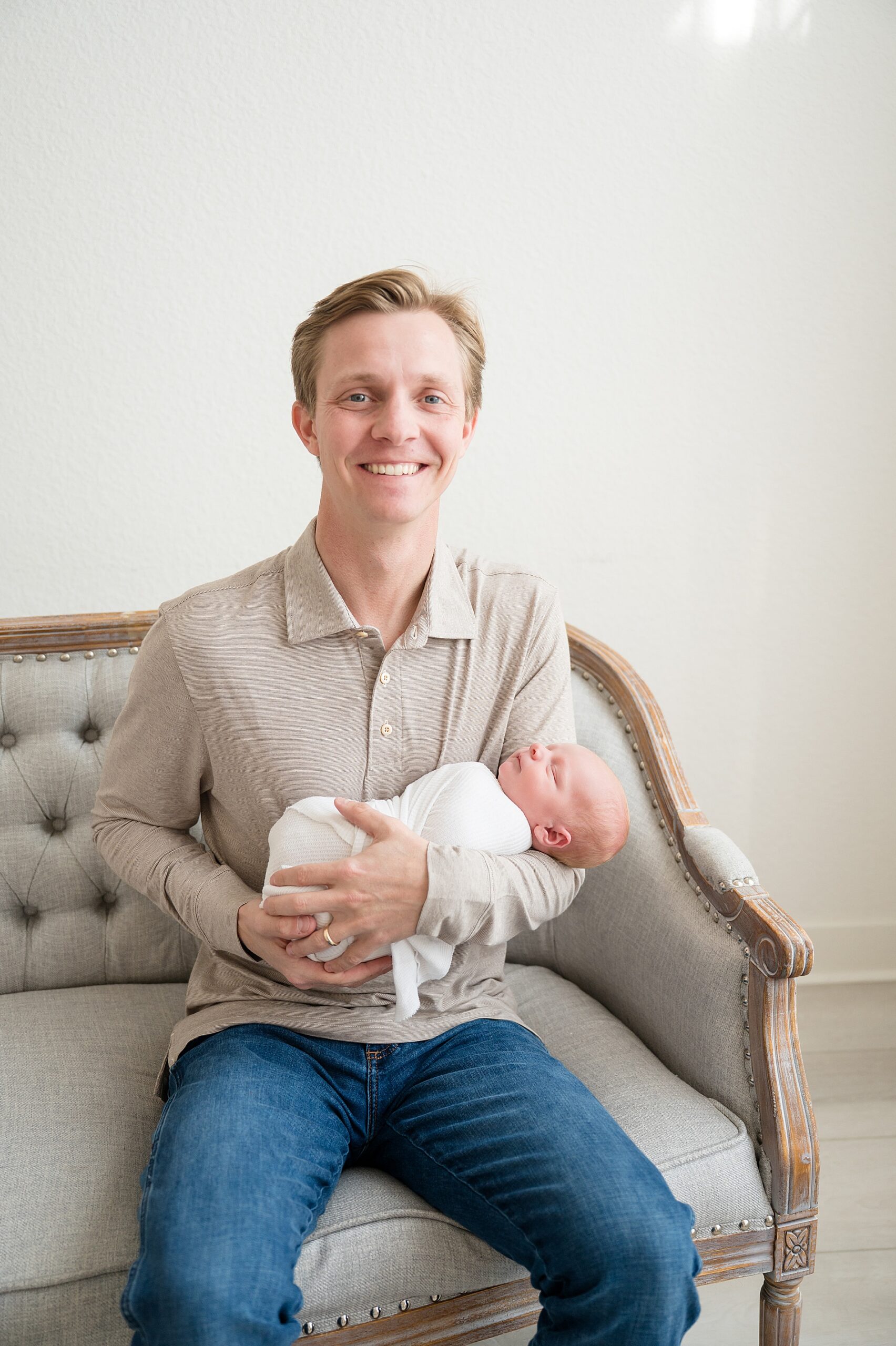 dad holds newborn during studio newborn session by Little Elm photographer 