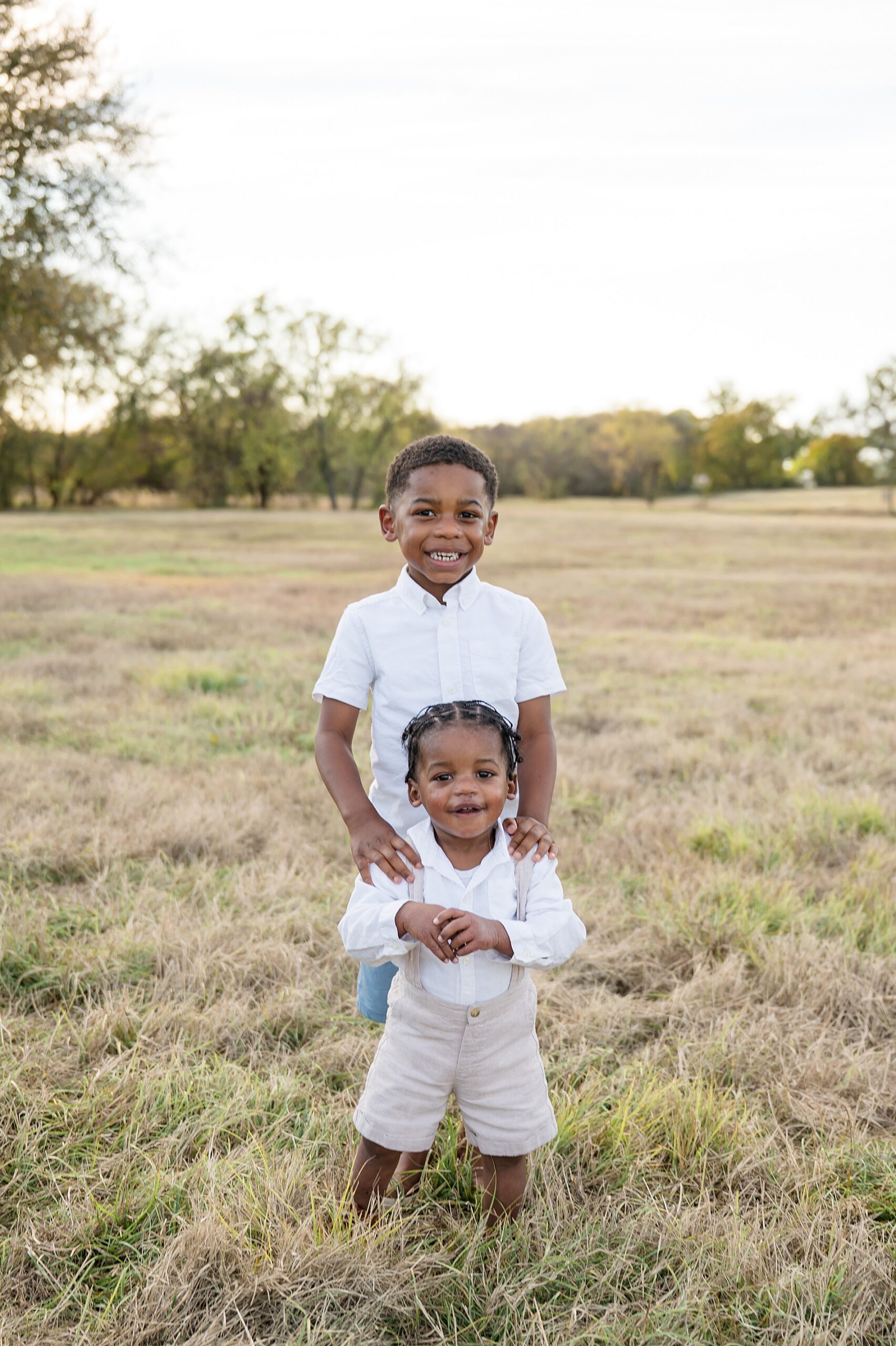 brothers stand together during autumn portraits in Dallas area
